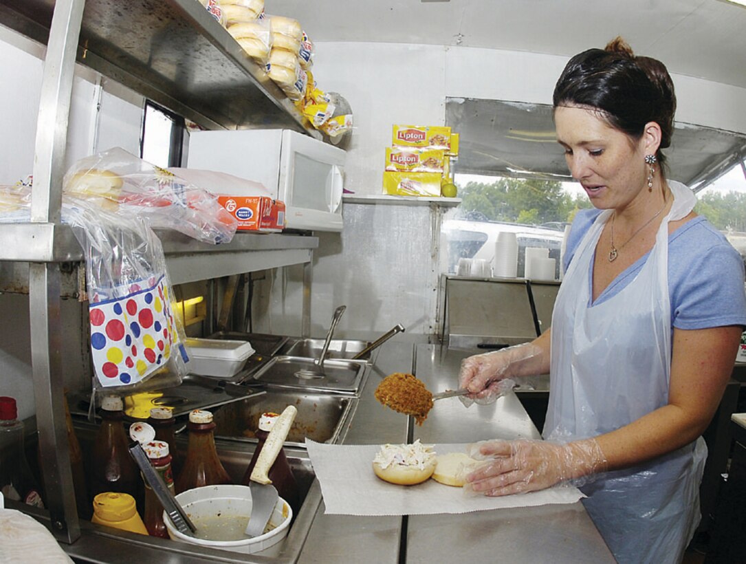 Loretta Windsor, owner of Loretta's Barbecue, prepares her signature barbecue pork and cole slaw sandwich for regular Team Andrews patron. (Photo by Bobby Jones)
