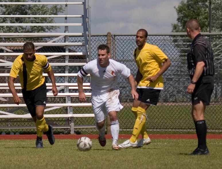 Mike Murphy, in white, 100th Operations Support Squadron and Mildenhall Marauders' player, is on the ball against members of the Ramstein Rams at USAFE soccer championship game at RAF Alconbury June 29. (Air Force photo Master Sgt. Jeffrey Waits)