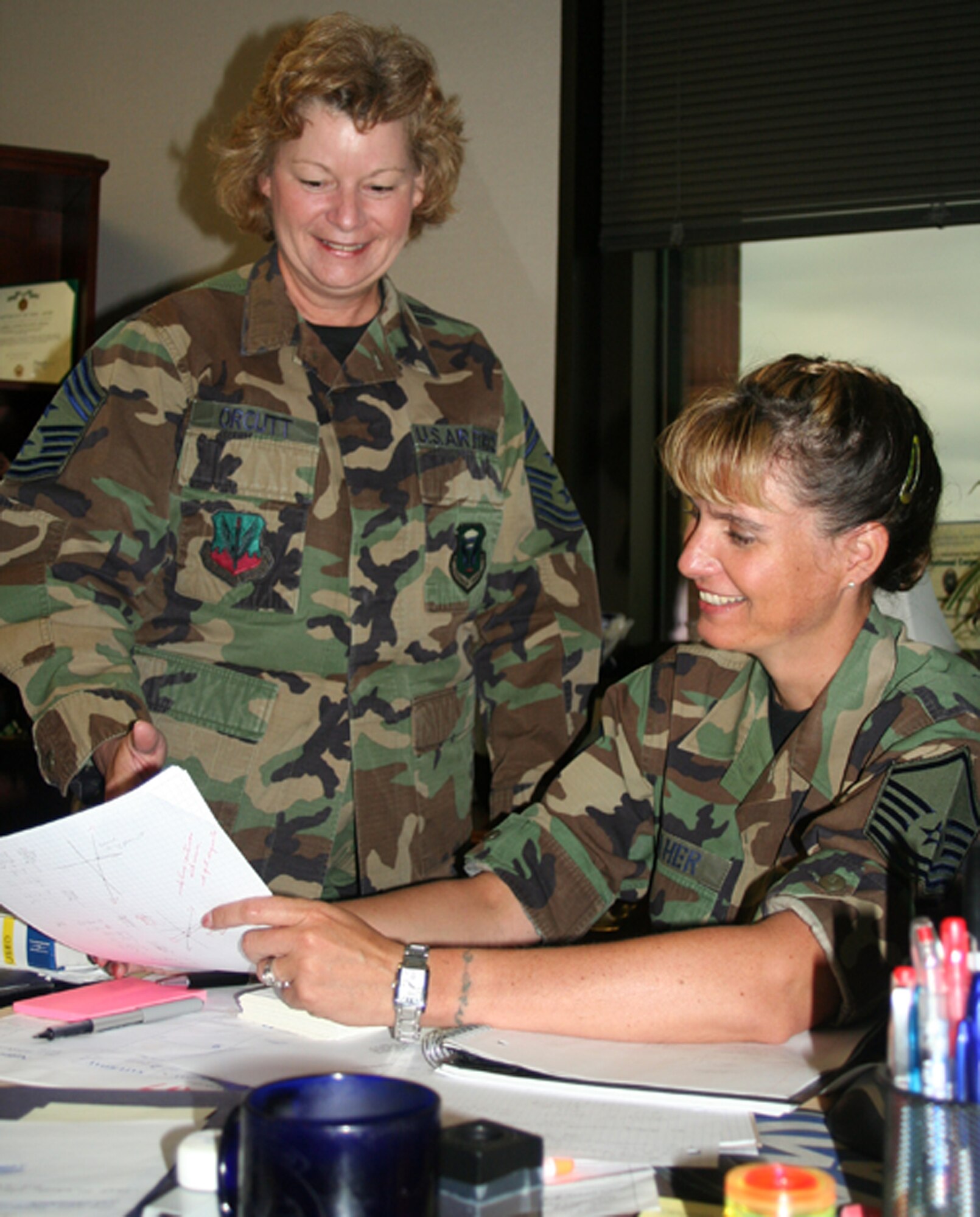 Chief Master Sgt. Chief Vicki Orcutt, 509th Bomb Wing command chief, and Master Sgt. Dana Fraher, discuss Chief Orcutt’s agenda during her last duty day June 20. (U.S. Air Force photo/Staff Sgt. Rob Hazelett)