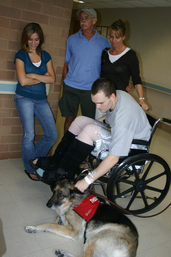 Army Pfc. James Oppelt spends some quality time with Jackson, a German shepherd therapy dog, at Brooke Army Medical Center while his fiancee, Andrea Preston, and parents, retired Marine Sgt. Patrick Oppelt and Sue Oppelt, look on. Photo by Jen Rodriguez