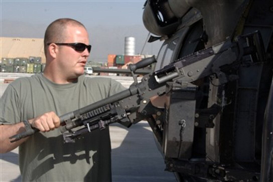 U.S. Army Spc. Justin Emrich inspects the M-240B machine gun on a UH-60 Black Hawk helicopter prior to take off at Bagram Airfield in the Parwan province of Afghanistan on June 29, 2007.  Emrich is assigned to the General Aviation Support Battalion, 82nd Combat Aviation Brigade, 82nd Airborne Division.  