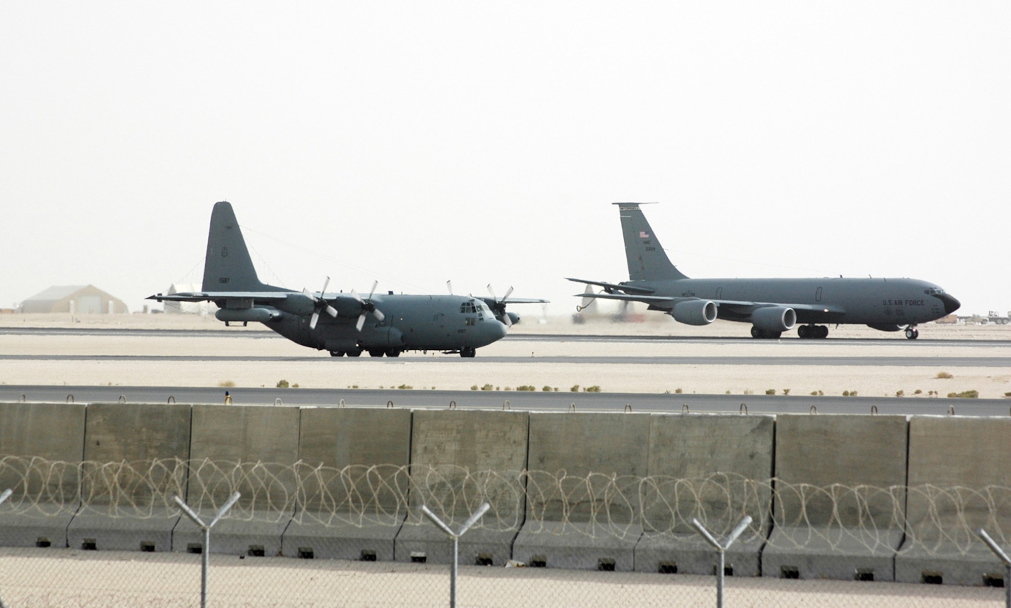 An EC-130H Compass Call from Davis-Monthan Air Force Base, Ariz., waits to take off at a deployed location in Southwest Asia while a KC-135 Stratotanker prepares for another refueling sortie. The Compass Call version of the C-130 Hercules is a versatile and flexible aircraft and its crew can bring the power of electronic combat to bear in virtually any combat situation. (U.S. Air Force photo/Senior Airman Clark Staehle)