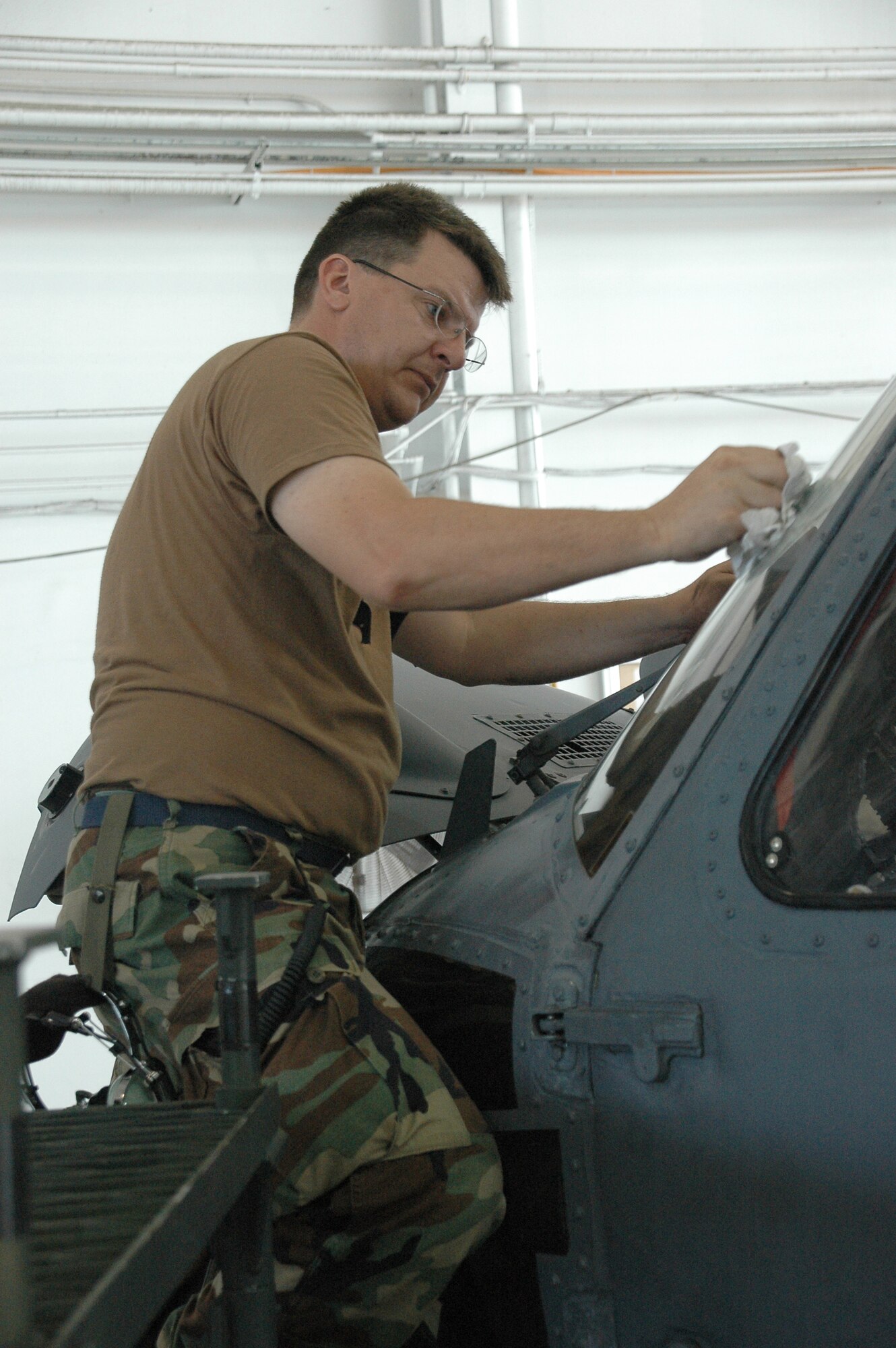 Air Force Reservist, Tech. Sgt. Russ Morris, a crew chief with the 920th Aircraft Maintenance Squadron, takes a moment to clean the windows of an HH-60G Pave Hawk helicopter after performing maintenance on the aircraft.  