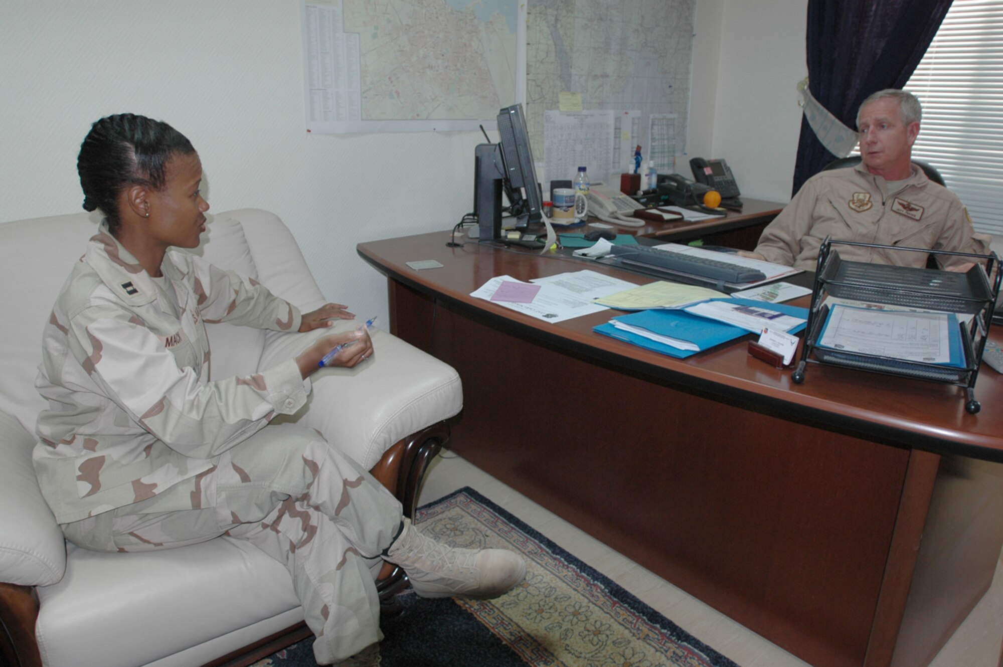Col. Jeff Fraser, 379th Air Expeditionary Wing vice commander (right), meets with Capt. Tonya Mack, 379th AEW chief of Protocol. Colonel Fraser meets with the wing staff agencies and group leadership to synchronize and coordinate ongoing efforts.   (U.S. Air Force Senior Aiman Clark Staehle)