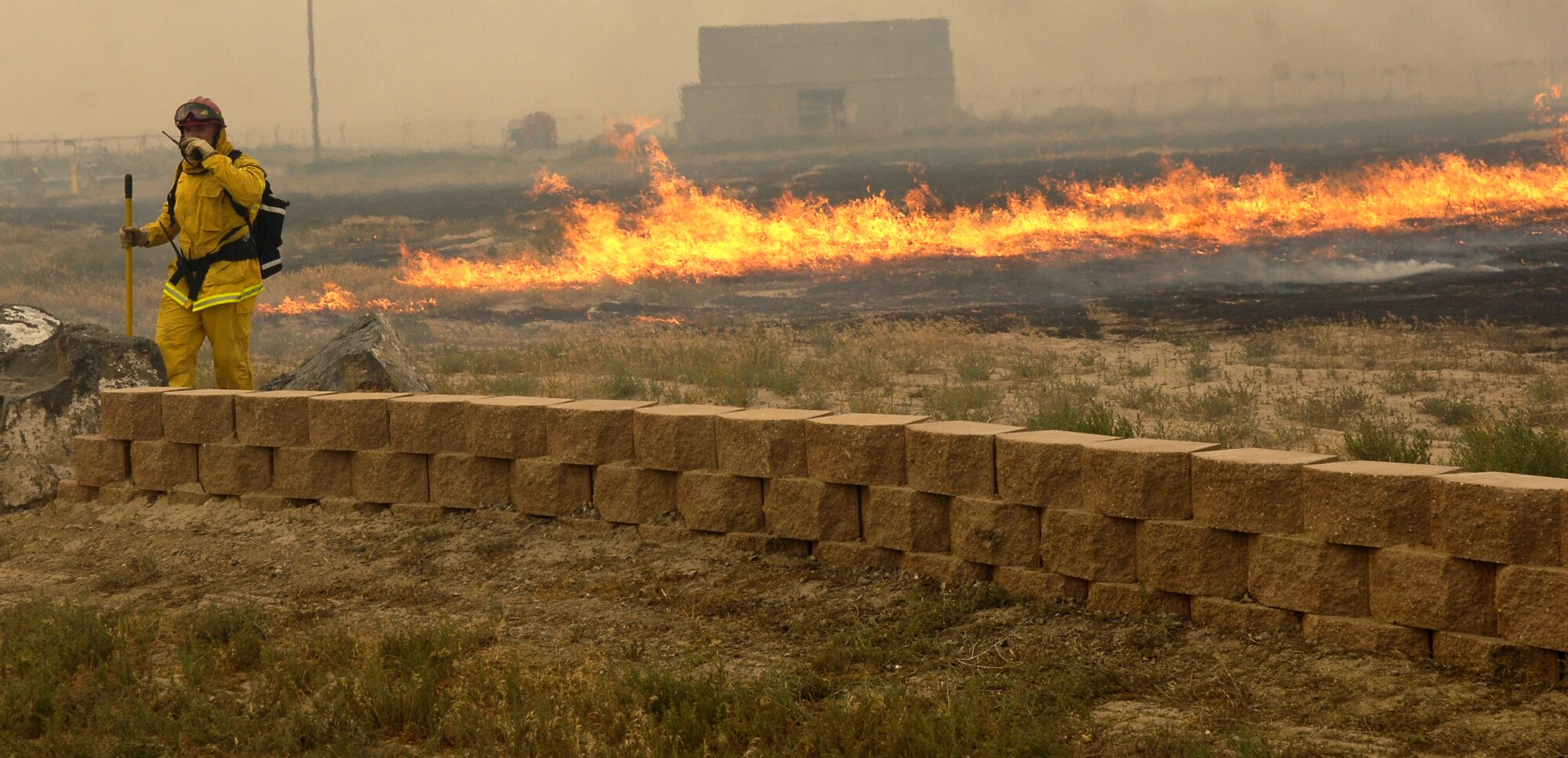 MOUNTAIN HOME AIR FORCE BASE, Idaho -- A base firefighter communicates with other firemen during a wildfire sparked by lightening near the Grandview Gate at approximately 6 p.m. July 6. Base Airmen, along with firemen from Mountain Home and the Idaho Bureau of Land Management, responded to one on-base fire and two off-base fires. The three fires consumed a combined total of almost 6,000 acres. (U.S. Air Force photo/Airman 1st Class Ryan Crane)