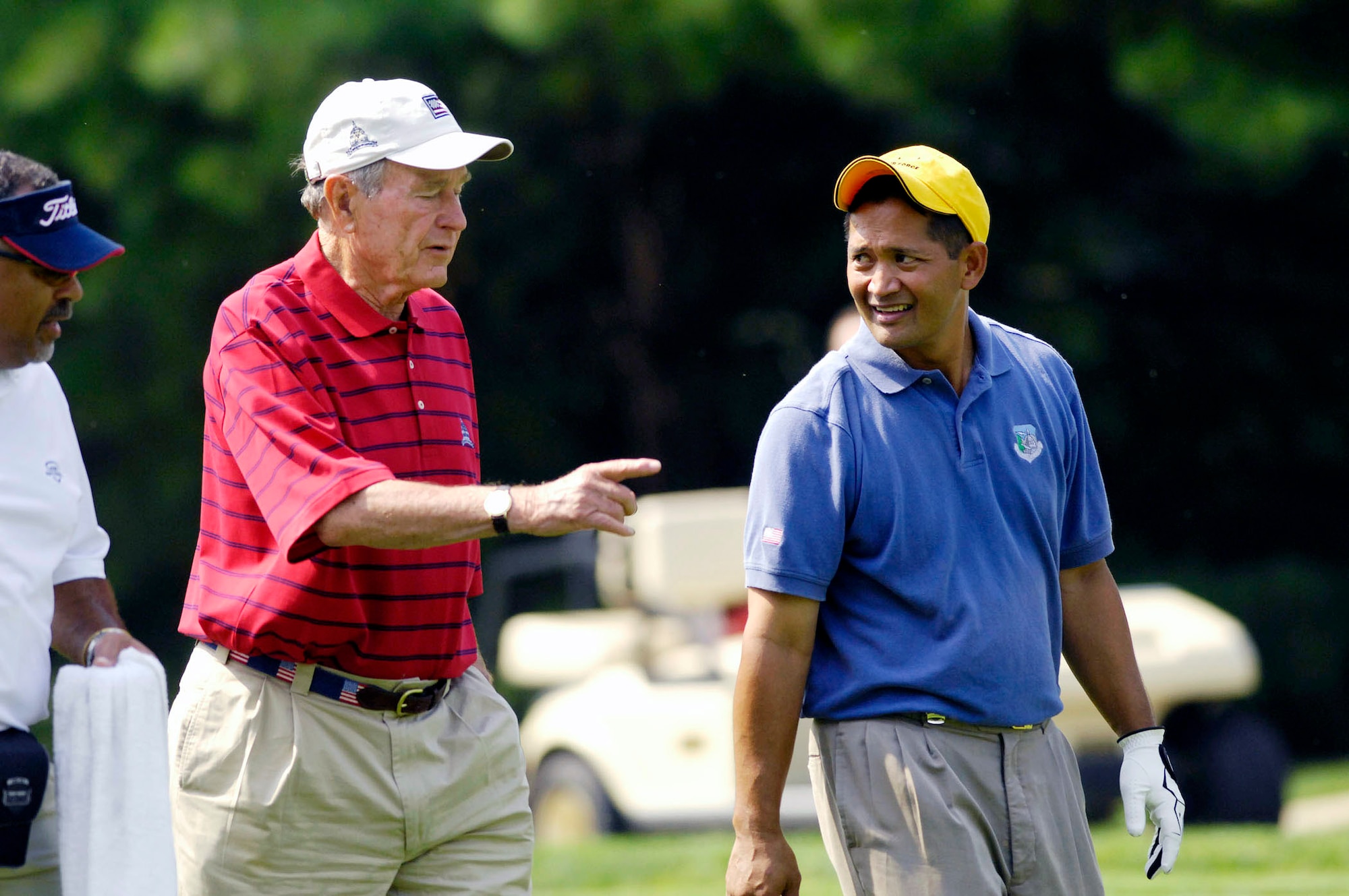 Tech. Sgt. Andy Amor walks down a fairway with former President George H.W. Bush during a Pro-Am tournament July 4 at Congressional Country Club in Bethesda, Md.  Sergeant Amor was selected to represent the Air Force and was paired with Tiger Woods at the event.  Mr. Woods was the event host as well as a contestant. Sergeant Amor is with the 316th Civil Engineer Squadron at Andrews Air Force Base, Md.  (U.S. Air Force photo/Senior Airman Dan DeCook)
