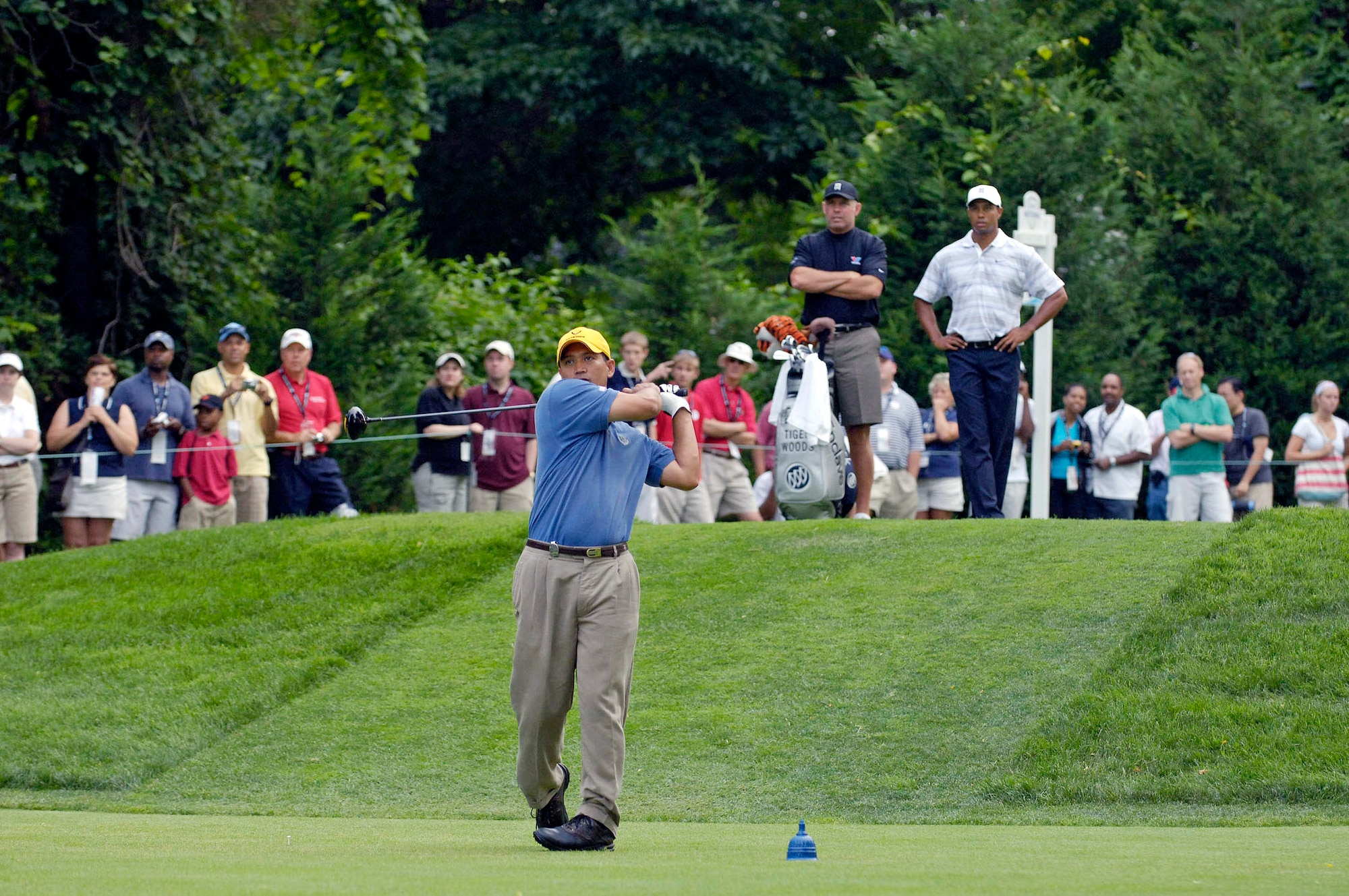 Tech. Sgt. Andy Amor tees off July 4 during a Pro-Am tournament at the Congressional Country Club in Bethesda, Md. as professional golfer Tiger Woods and his caddie Steve Williams watch.  Sergeant Amor was selected to represent the Air Force in the event.  Mr. Woods was the event host as well as a contestant. Sergeant Amor is with the 316th Civil Engineer Squadron at Andrews Air Force Base, Md.  (U.S. Air Force photo/Senior Airman Dan DeCook)