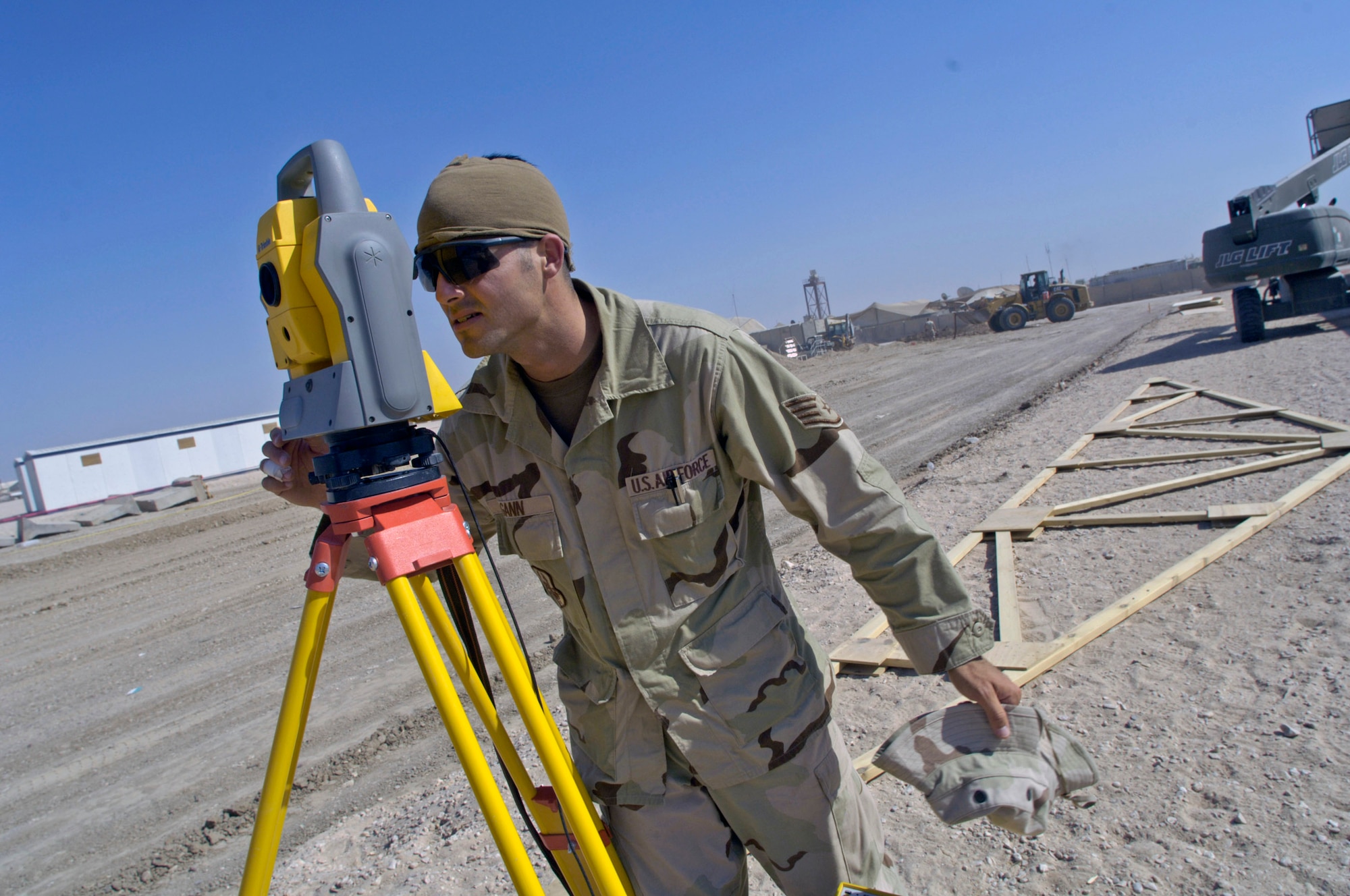 Staff Sgt. Sean Gann reads data from a total station used to position offset corner markers for the placement of a tactical operations center June 22 at Forward Operating Base Kalsu, Iraq. Sergeant Gann is an engineer assistant with the 557th Expeditionary RED HORSE Squadron deployed from the 820th RED HORSE Squadron at Nellis Air Force, Nev. He is originally from Bartow, Fla. Sergeant Gann and his fellow Rapid Engineer Deployable Heavy Operational Repair Squadron Engineers, or RED HORSE, Airmen are forward deployed from Balad Air Base, Iraq, to build four tactical operations centers for the Army's 2nd Brigade combat team, 3rd Infantry Division headquartered here. The 2/3 ID is currently running operations out of tents. The Air Force RED HORSE unit, made up of Air Guard, Reserve and active-duty Airmen, was requested by the Army to come into this "Triangle of Death" location because of their self-suffiency and for the multiple skill sets they bring to a project. (U.S. Air Force photo/Master Sgt. Jim Varhegyi)