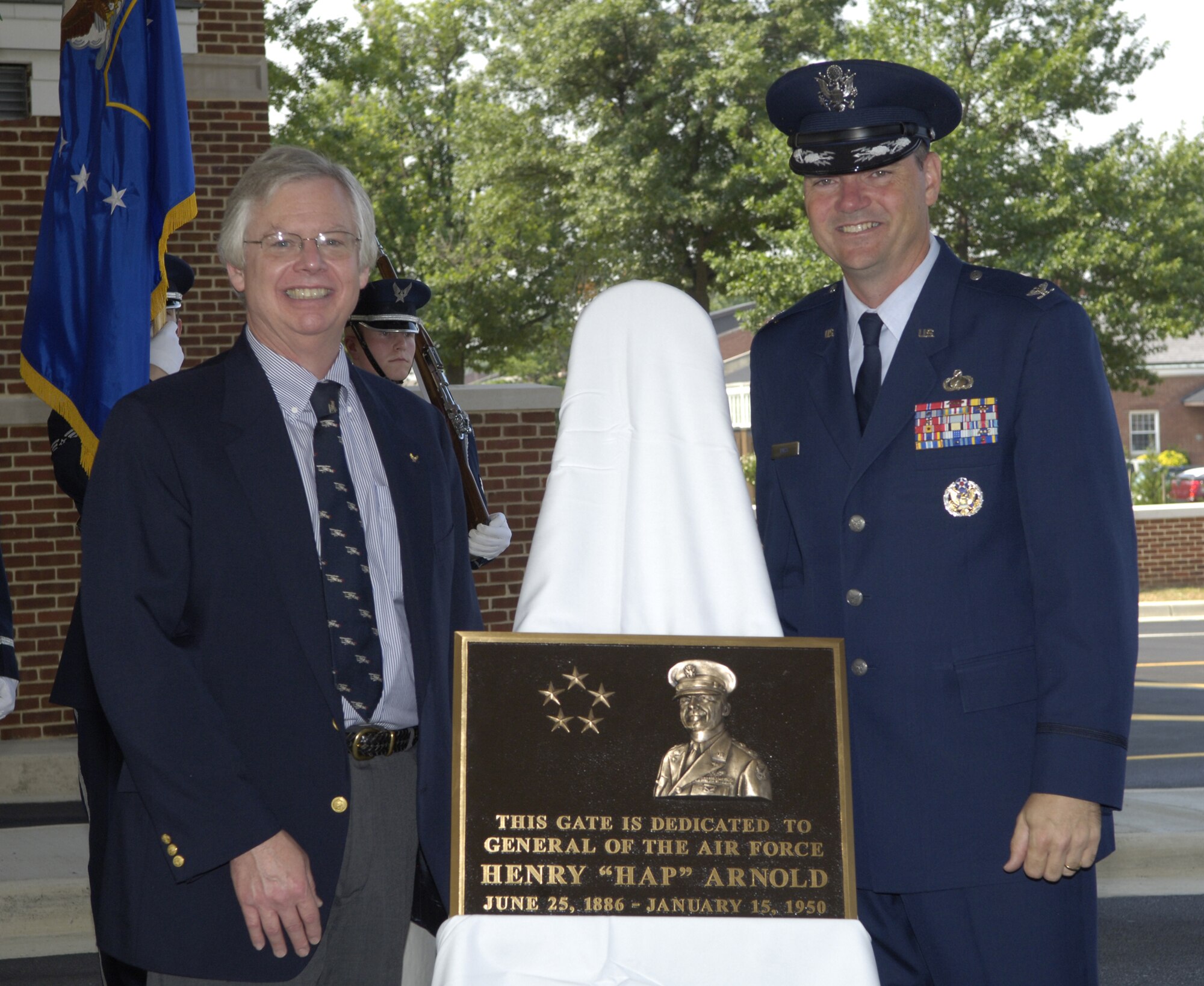 Robert Arnold, grandson of Gen. Henry H. “Hap” Arnold, the first and only five-star General of the Air Force (1949), and Col.Terry Ross, 11th Wing vice commander, unveil the General Arnold dedication plaque during the Main Gate and Avenue of Flag Dedication Ceremony on Bolling July 9.  (U.S. Air Force photo by Staff Sgt. Catherine Thompson)