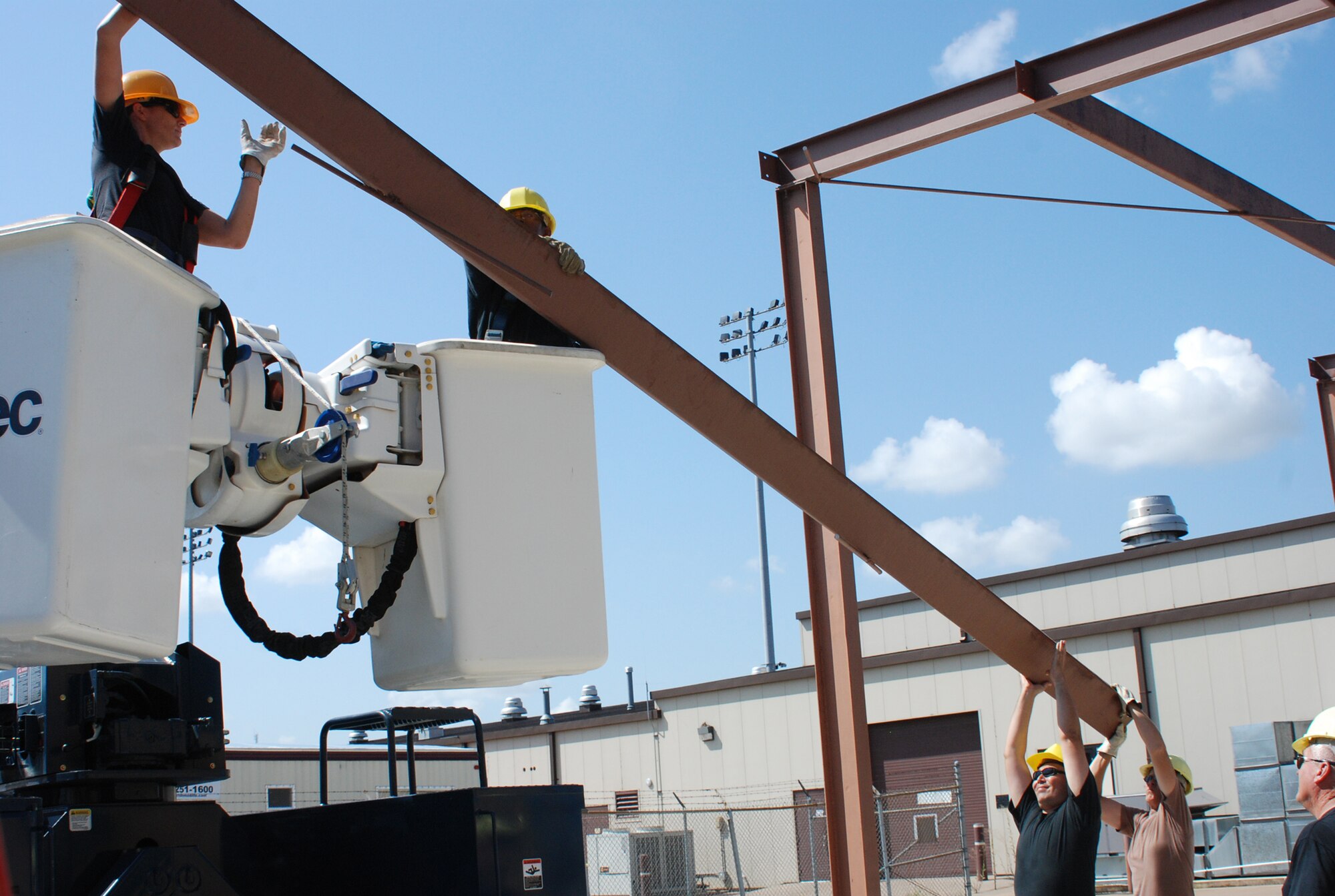 (l to r) Staff Sgt. Krista Kenoyer and Tech. Sgt. Julius Gordon, both from the 301st Civil Engineer Squadron, supports a beam while other members of the demolition team ease the beam to the ground. The CE team worked together to disassemble the entire building’s frame in one day located at the Naval Air Station Joint Reserve Base, Fort Worth, Texas. (U.S. Air Force Photo/Tech. Sgt. Julie Briden-Garcia)
