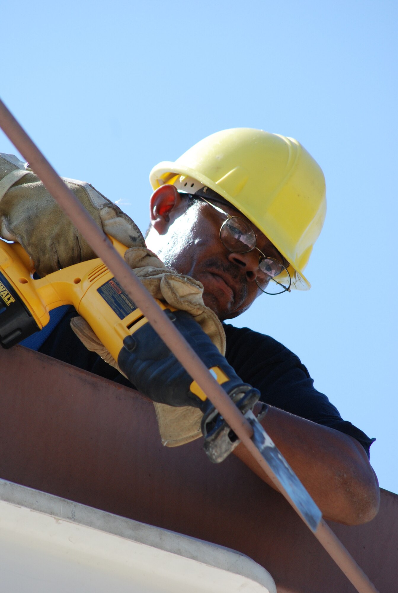 Tech. Sgt. Julius Gordon, an electrical craftsman from the 301st Civil Engineer Squadron, severs a rod that's stabilizing a building’s support beam. The CE team worked together to disassemble the entire building’s frame located at the Naval Air Station Joint Reserve Base, Fort Worth, Texas. (U.S. Air Force Photo/Tech. Sgt. Julie Briden-Garcia)