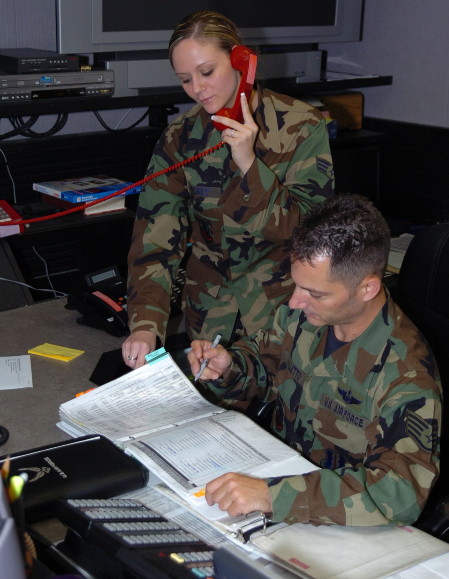 Senior Airman Jeri Hickey and Staff Sgt. Christopher Galletto, 33d Fighter Wing Command Post controllers, review their checklist during the hurricane exercise June 25-29 at Eglin Air Force Base, Fla. The command post plays a role in almost every aspect of a base's day-to-day mission, as well as during times of emergency or disaster. In addition, it supports a variety of missions during deployment, such as flight following, commander support, and monitoring theater ballistic missile defense systems. (U.S. Air Force photo by Staff Sgt. Bryan Franks)