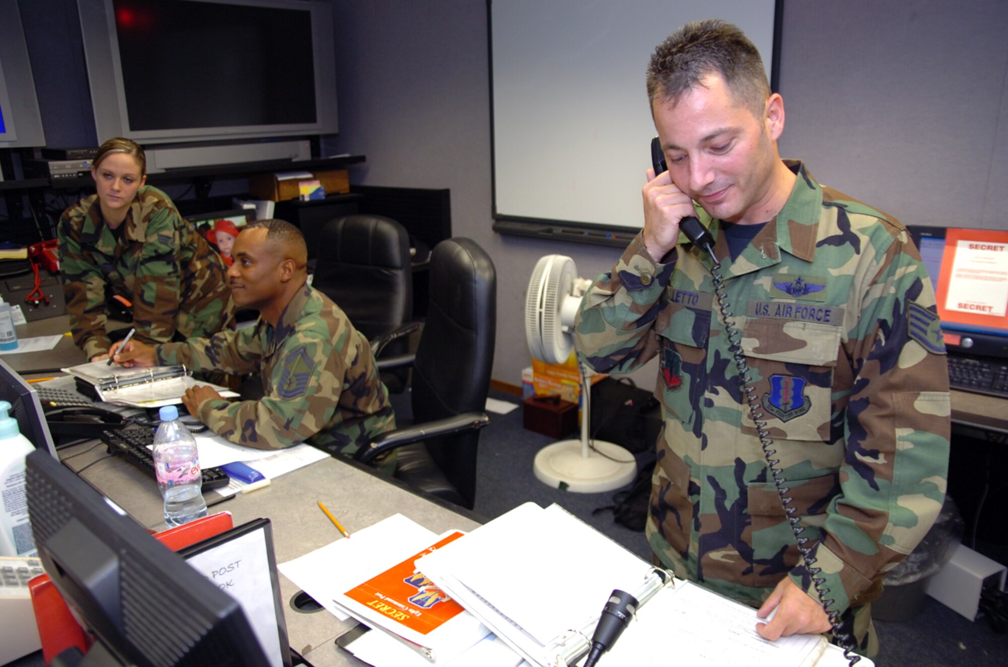 Staff Sgt. Christopher Galletto, Senior Master Sgt. Roderick Dycus and Senior Airman Jeri Hickey, 33d Fighter Wing Command Post controllers, review their checklist during the hurricane exercise June 25-29 at Eglin Air Force Base, Fla. The command post plays a role in almost every aspect of a base's day-to-day mission, as well as during times of emergency or disaster. In addition, it supports a variety of missions during deployment, such as flight following, commander support, and monitoring theater ballistic missile defense systems. (U.S. Air Force photo by Staff Sgt. Bryan Franks)