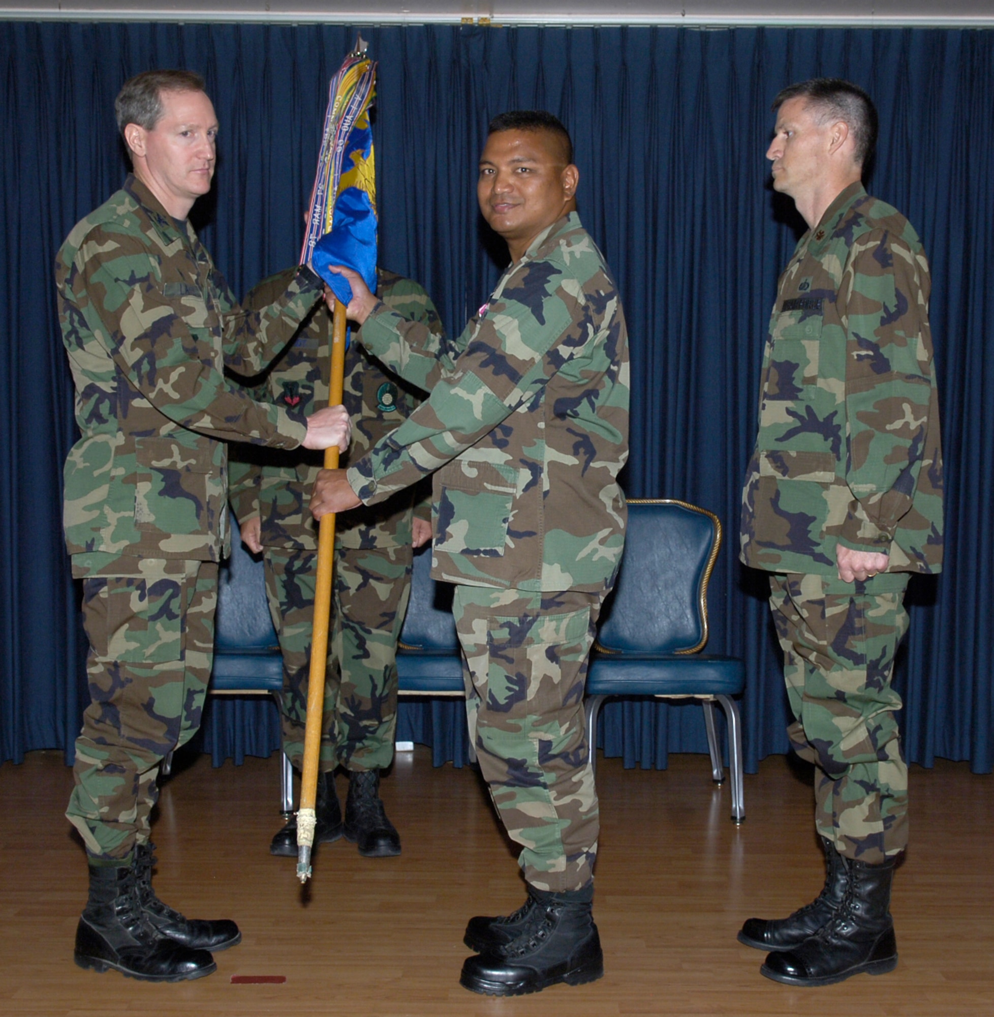 MOUNTAIN HOME AIR FORCE BASE, Idaho -- From left, Col. Thomas Laffey, 366th Mission Support Group commander, accepts the 366th Services Squadron guidon from Lt. Col. Anthony Lanuzo before passing it to incoming commander Maj. James Beaty during the squadron's change of command ceremony here July 6. Major Beaty previously served as the military support branch chief at Air Combat Command headquarters, Langley Air Force Base, Va. Lt. Col. Anthony Lanuzo, the squadron’s former commander, left Mountain Home to join the Air Force Services Agency at the Pentagon. (Air Force photo/Airman 1st Class Ryan Crane)