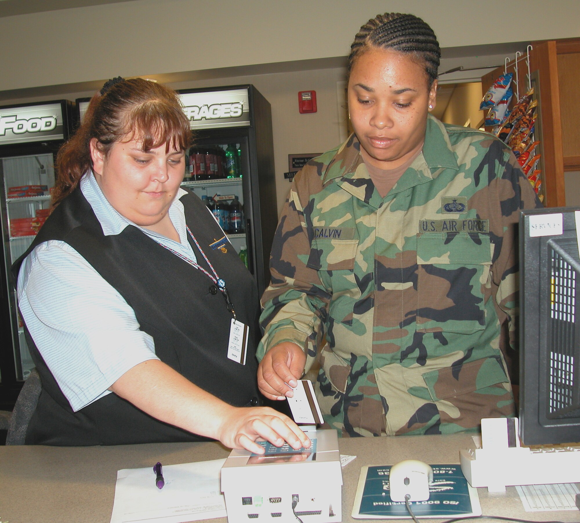 GRISSOM AIR RESERVE BASE, Ind., -- Blair Jeffers, left, a civilian employee with the 434th Services Flight lodging office, instructs Tech. Sgt. Felita Calvin on the operation of the billeting key card coding system.  Personnel (with reservations) arriving after billeting office hours, can obtain their preprogramed  room card from the electronic lock boxes located in the lobby.  (U.S. Air Force photo/Senior Airman Chris Bolen)