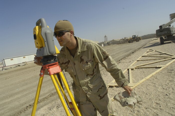 Staff Sgt. Sean Gann, an engineer assistant with the 557th Expeditionary RED HORSE Squadron (ERHS) whose unit is deployed from the 820th RHS at Nellis AFB, reads data from a Total Station, which he's using to position offset corner markers on Friday, June 22 for the placement of a tactical operations center (TOC). Sergeant Gann is deployed from the 820th RED HORSE Squadron at Nellis Air Force, Nev. He is originally from Bartow, Fla. Sergeant Gann and his fellow Rapid Engineer Deployable Heavy Operational Repair Squadron Engineers RED HORSE Airmen are forward deployed from Balad Air Base, Iraq, to build four tactical operations centers (TOCs) for the Army's 2nd Brigade combat team, 3rd Infantry Division headquartered here. The 2/3 ID is currently running operations out of tents. The Air Force RED HORSE unit, made up of Air Guard, Reserve and active duty Airmen, was requested, by the Army, to come into this "Triangle of Death" location because of their self-suffiency and for the multiple skill sets they bring to a project. Besides the TOCs the RED HORSE Airmen are working on several other projects at the FOB. (U.S. Air Force photo by Master Sgt. Jim Varhegyi)