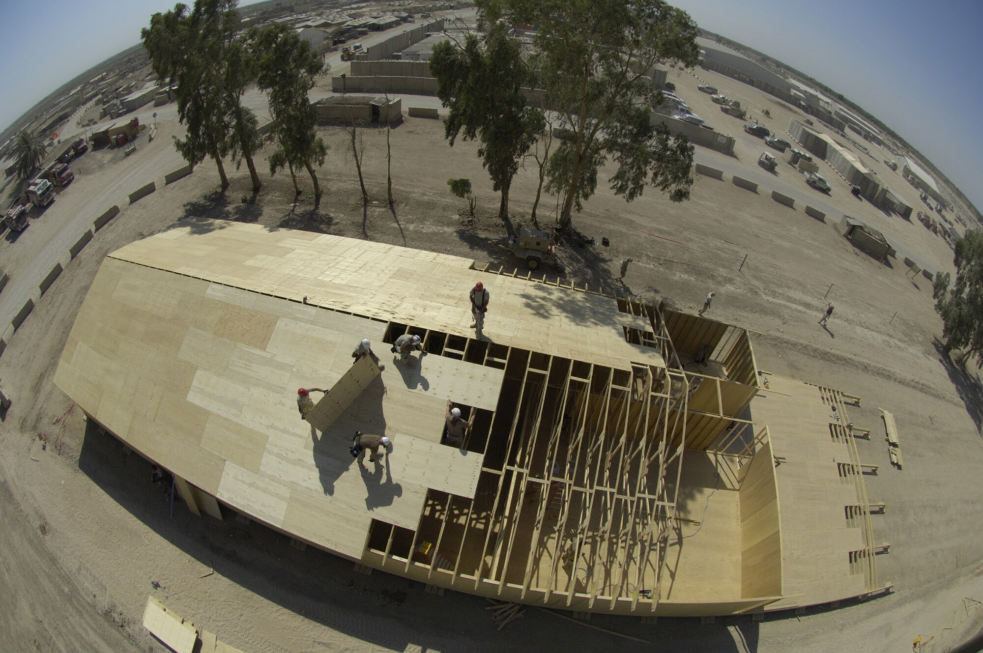 Airmen with the 557th Expeditionary RED HORSE Squadron (ERHS), work on the roof of a tactical operations center  (TOC) on Friday, June 22, 2007. The Rapid Engineer Deployable Heavy Operational Repair Squadron Engineers RED HORSE Airmen are forward deployed from Balad Air Base, Iraq, and are tasked to build four tactical operations centers (TOCs) for the Army's 2nd Brigade combat team, 3rd Infantry Division headquartered here. The 2/3 ID is currently running operations out of tents. The Air Force RED HORSE unit, made up of Air Guard, Reserve and active duty Airmen, was requested, by the Army, to come into this "Triangle of Death" location because of their self-suffiency and for the multiple skill sets they bring to a project. Besides the TOCs the RED HORSE Airmen are working on several other projects at the FOB. (U.S. Air Force photo by Master Sgt. Jim Varhegyi)