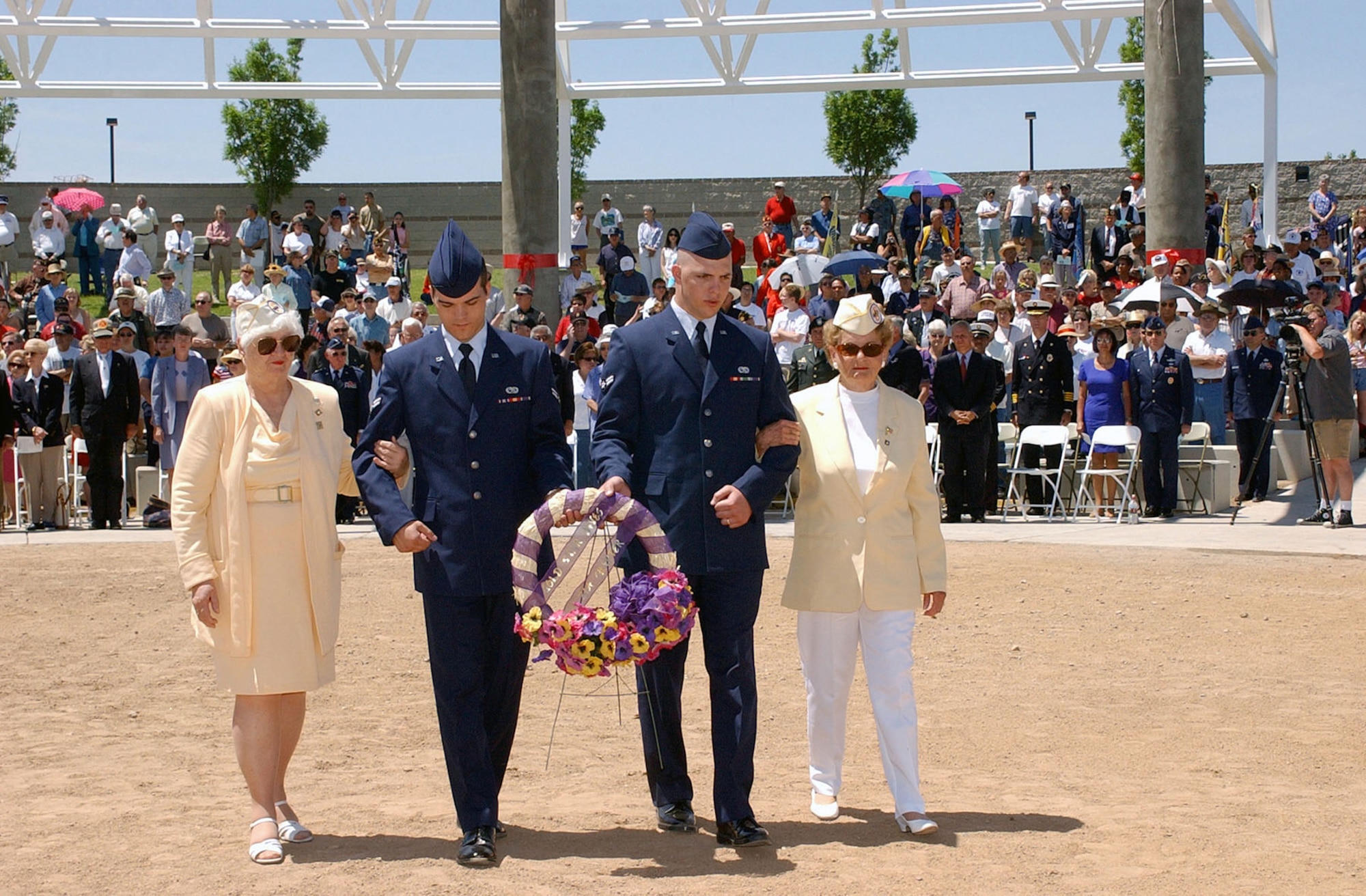 Remembering those who died for our freedom: two members of the 377th Security Forces Squadron (SFS), Master Sergeant (MSGT) Timothy Uding and Senior Airman (SRA) Neng Hang, escort God Star Mothers Carmen Lopez and Florence Williams, while they place a wreath in remembrance of sons and daughters who did not return from war, at the New Mexico Veterans Memorial Park, Albuquerque, N.M. (Photo courtesy of DVIC)