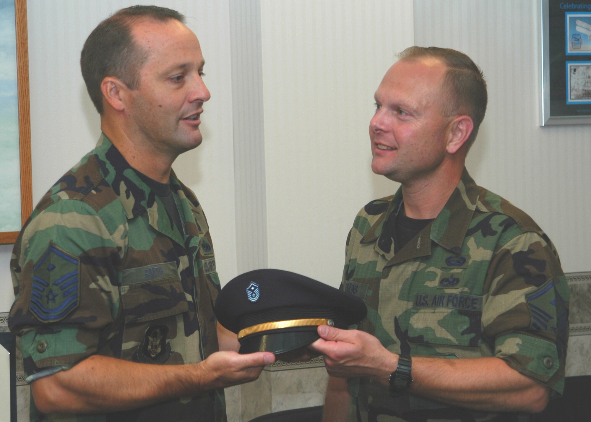 GRISSOM AIR RESERVE BASE, Ind., -- Master Sgt. Kevin Smith, left, first sergeant for the 434th Mission Support Squadron, passes a symbolic hat to Grissom's newest first sergeant, Master Sgt. Timmie Hoskins, the first sergeant for the 434th Operations Support Squadron. The newest first sergeant must carry that hat to meetings and functions as a right of passage until a new diamond enters the fold. (U.S. Air Force photo/Tech. Sgt. Doug Hays)