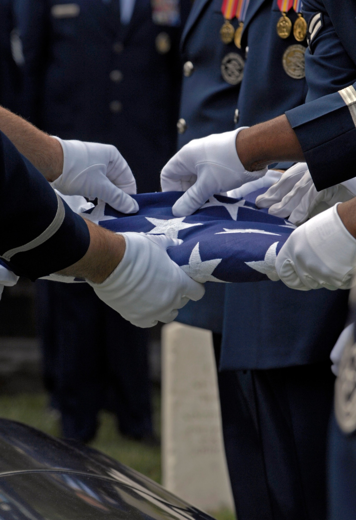 Air Force Honor Guard pallbearers fold the United States flag in honor of former Chief Master Sergeant of the Air Force Gary R. Pfingston at his burial site July 6 at Arlington National Cemetery, Va.  The 10th CMSAF was born in Evansville, Ind., and entered the Air Force in February 1962. He passed away June 23 in San Antonio. (U.S. Air Force photo/Senior Airman Rusti Caraker)