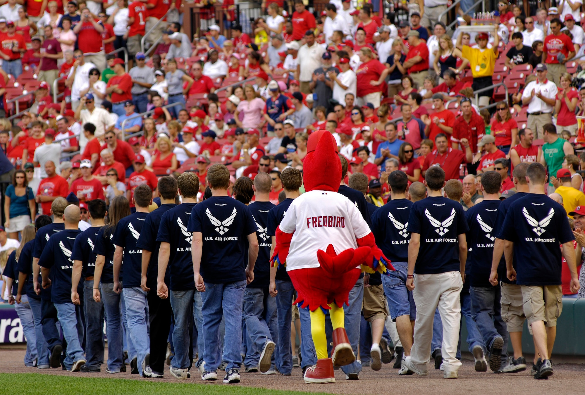St. Louis Cardinals mascot, Fredbird, marches out with 40 young men and women who were just sworn in to the Air Force during a pregame Air Force Week St. Louis event July 7.  Gen. Duncan J. McNabb, Air Mobility Command commander at nearby Scott Air Force Base, Ill., administered the Oath of Enlistment to the group just prior to the Cardinals-Giants baseball game.  (U.S. Air Force photo/Staff Sgt. Brian Ferguson)