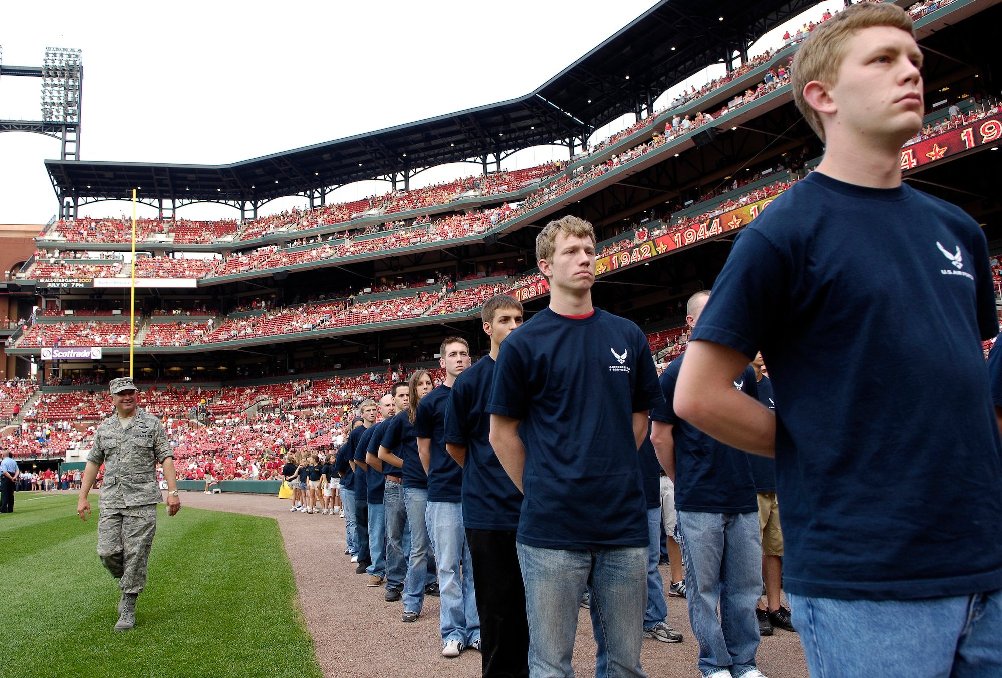 Gen. Duncan J. McNabb, Air Mobility Command commander at nearby Scott Air Force Base, Ill, "inspects" a group of 40 young men and women before giving them the Oath of Enlistment at a St. Louis Cardinals baseball game July 7 during Air Force Week in St. Louis.  The soon-to-be Airmen were enlisted during pregame activities.  (U.S. Air Force photo/Staff Sgt. Brian Ferguson)