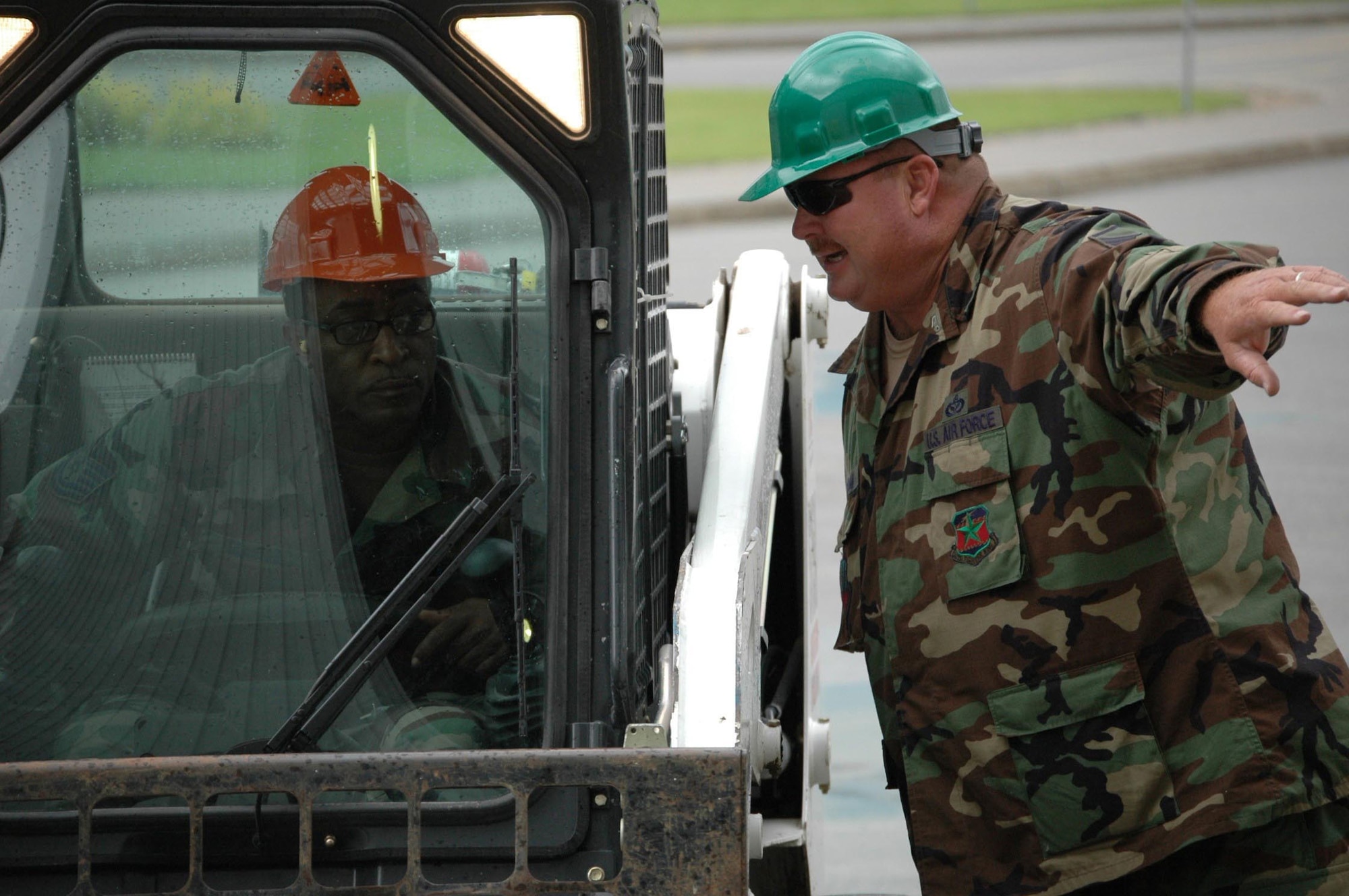 Master Sgt. Tim "Bull" Durham (right) provides guidance to Technical Sgt. Rodney Blanton as Sergeant Blanton prepares to drive a Bobcat on site in Moose Jaw. (Texas National Guard photo/Senior Master Sgt. Marcus Falleaf)
