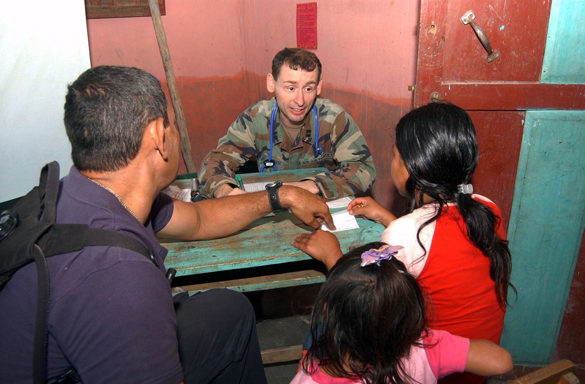 Capt. (Dr.) William Ingram talks to a patient with the help of interpreter Rafael Castro during a Medical Readiness Training Exercise June 29 in El Horno, Honduras. The medical team saw 1,072 patients during the two-day mission. Captain Ingram is a physician's assistant with the Medical Element at Soto Cano Air Base, Honduras. (U.S. Air Force photo/Tech. Sgt. Sonny Cohrs)