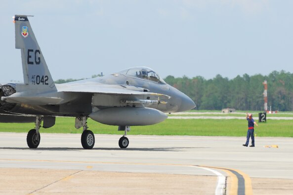 Tim Bourgeois, Defense Contract Services Incorporated transient alert technician, directs an arriving F-15 Eagle into a parking location July 2 at Moody Air Force Base, Ga. The aircraft was unable to land at Eglin AFB, Fla., its home station, due to severe weather. By the end of the day, 22 F-15’s were forced to divert to Moody, the largest number the base has ever received. (U.S. Air Force photo by Tech. Sgt. Parker Gyokeres)