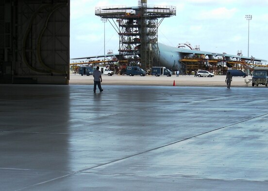 The 433rd Aircraft Maintenance Squadron inspection hangar floor recieved a new finish reducing the risk of slipping and greatly improving the use of hangar lighting. The reflective nature of the paint-on floor increases visibility during inspections and will allow the maintainers to see leaks and imperfections during the inspection of C-5 aircraft. The increased visibility in the hangar makes it a safer and more efficient work environment for the AMXS maintainers. (US Air Force photo/ Master Sgt. Laurence Tilghman)