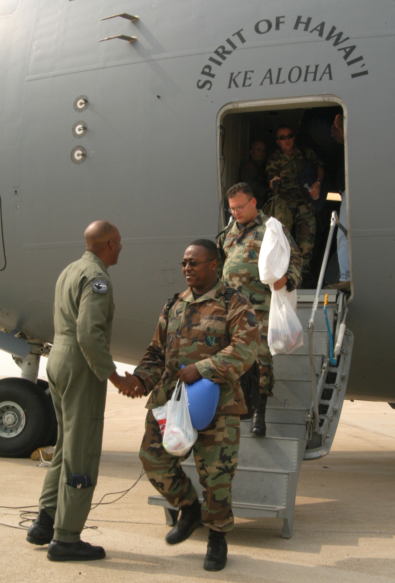 KUNSAN AIR BASE, Republic of Korea -- Col. CQ "Wolf" Brown, 8th Fighter Wing commander, greets 555th Expeditionary Fighter Squadron "Triple Nickel" maintainers as they depart a C-17 Globemaster III July 8. The C-17 Globemaster III, assigned to Hickam Air Force Base, Hawaii, airlifted more than 40 maintainers and equipment  from the 555th EFS as part of their air expeditionary force requirements. More than 10 F-16 Fighting Falcons assigned to the Triple Nickel arrived July 7. (U.S. Air Force photo/Senior Airman Stephen Collier)                                                              