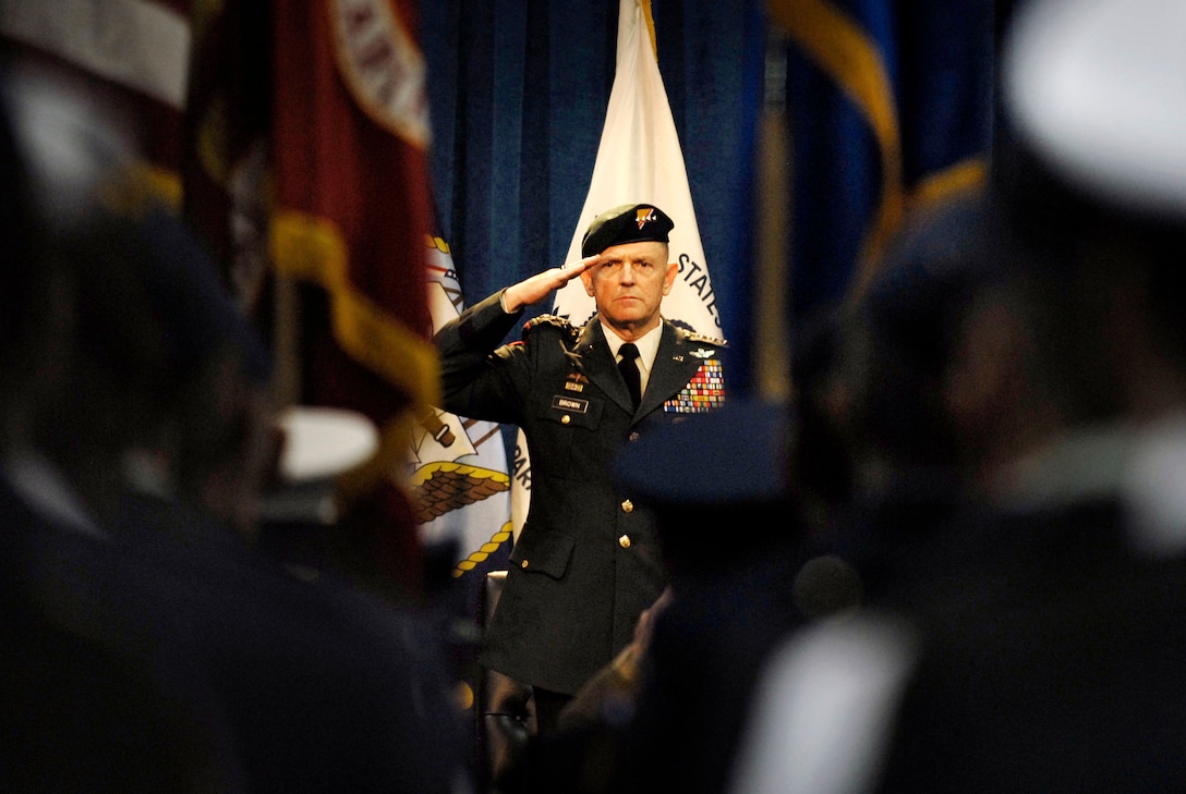 U.S. Army Gen. Doug Brown, commander of U.S. Special Operations Command, salutes during the singing of the national anthem during a change of command ceremony presided over by Secretary of Defense Robert M. Gates at the Tampa Convention Center in Tampa, Fla., July 9, 2007.  Brown, who has commanded USSOCOM since September 2003, is retiring from active duty after 40 years of service to the nation.  Navy Adm. Eric T. Olson, who has been the deputy commander of USSOCOM since September 2003, took over command.