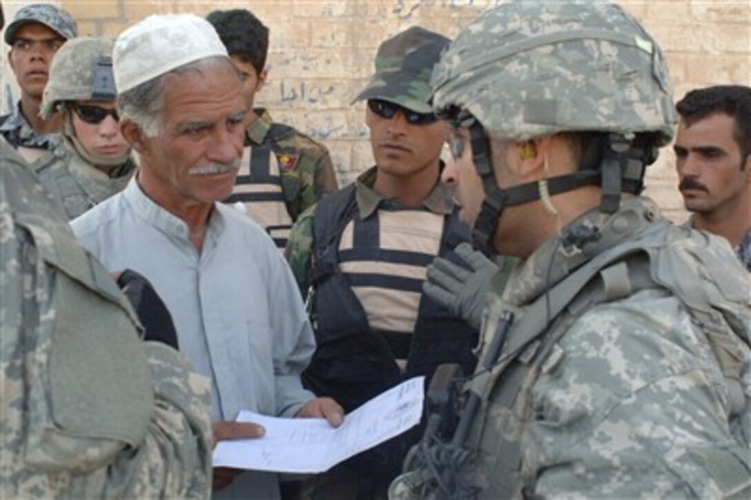 Army Staff Sgt. Jose Vera (right) speaks to a local resident during operations with Iraqi army soldiers in the Khamaliyah area of Baghdad, Iraq, on June 27, 2007.  
