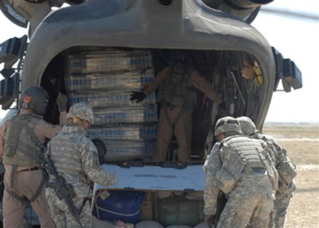 Soldiers of the Sharana Provincial Reconstruction Team unload a helicopter of humanitarian aid supplies near the village of Janan Kala in Paktika province, Afghanistan.