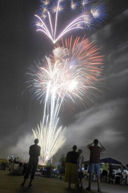 Airmen and their families look on as fireworks shoot over Heritage Park here during the Fourth of July celebration. (U.S. Air Force photo/Senior Airman Christina D. Ponte)