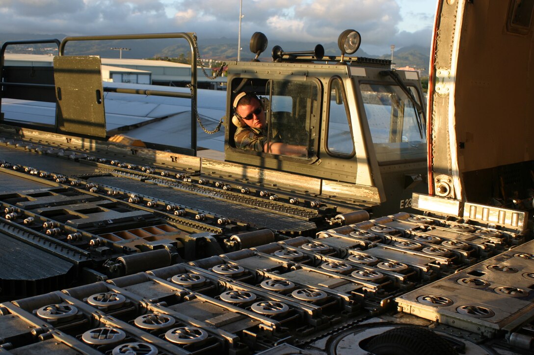 HICKAM AFB, Hawaii - Senior Airman Bryan Reed, ramp services specialist from the 87th Aerial Port Squadron deployed from Wright-Patterson AFB, Ohio waits for cargo pallets to be unloaded from an Atlas Airlines 747 aircraft onto a 40-K loader he is driving at Hickam AFB, Hawaii. (U.S. Air Force photo/Master Sgt. Doug Moore)