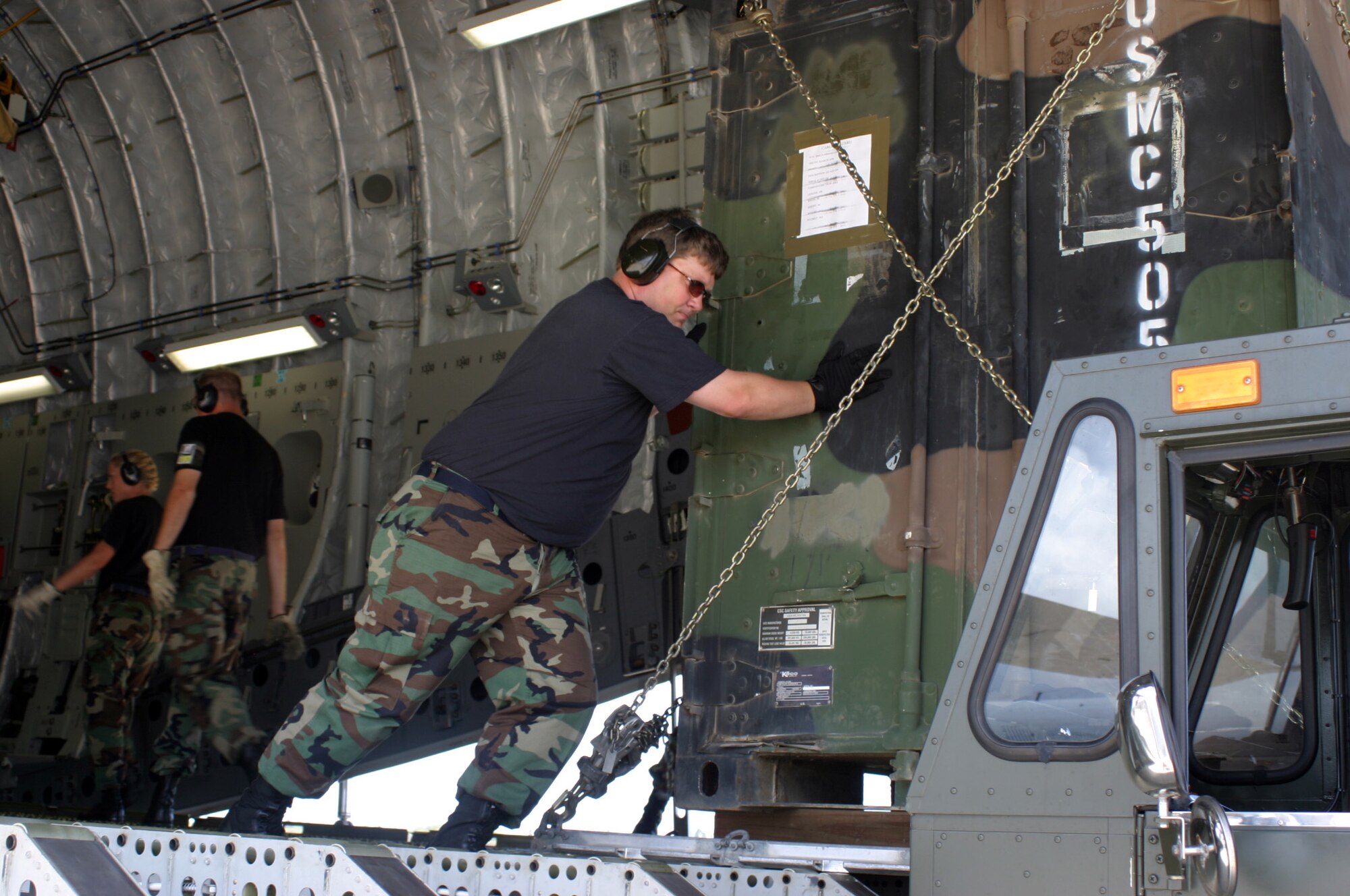 HICKAM AFB, Hawaii - Staff Sgt. Otis Crisp, ramp services specialist from the 87th Aerial Port Squadron deployed from Wright-Patterson AFB, Ohio pushes a cargo pallet from a C-17 aircraft onto a 40-K loader at Hickam AFB, Hawaii. (U.S. Air Force photo/Master Sgt. Doug Moore)