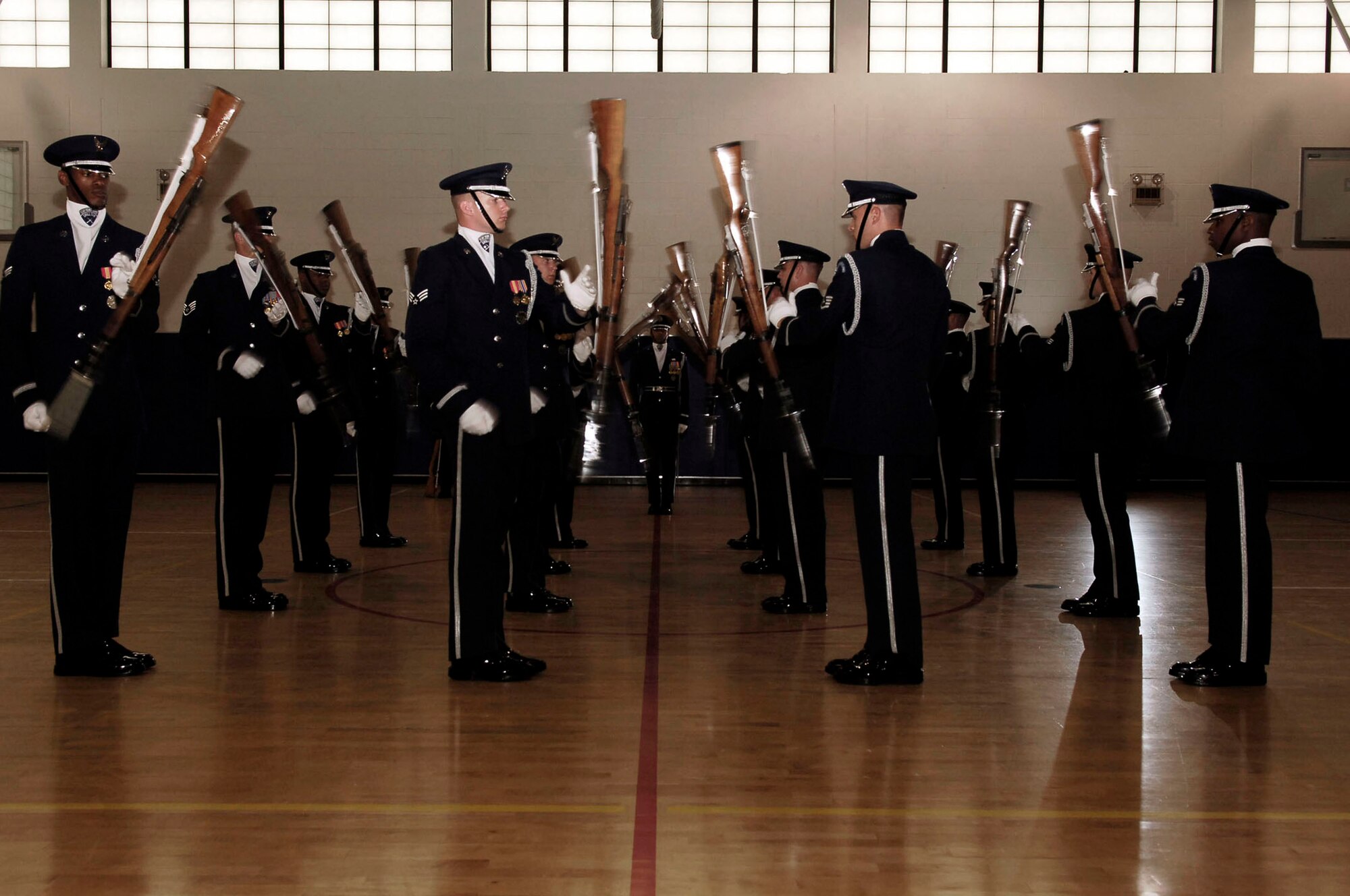 The U.S. Air Force Honor Guard Drill Team performs a drill at the base fitness center July 9. The Drill team tours with the large 16-man sequence, featuring a professionally choreographed 20-minute routine full of weapon manuals, tosses, and complex weapon exchanges. (U.S. Air Force photo by Senior Airman Bradley Lail)