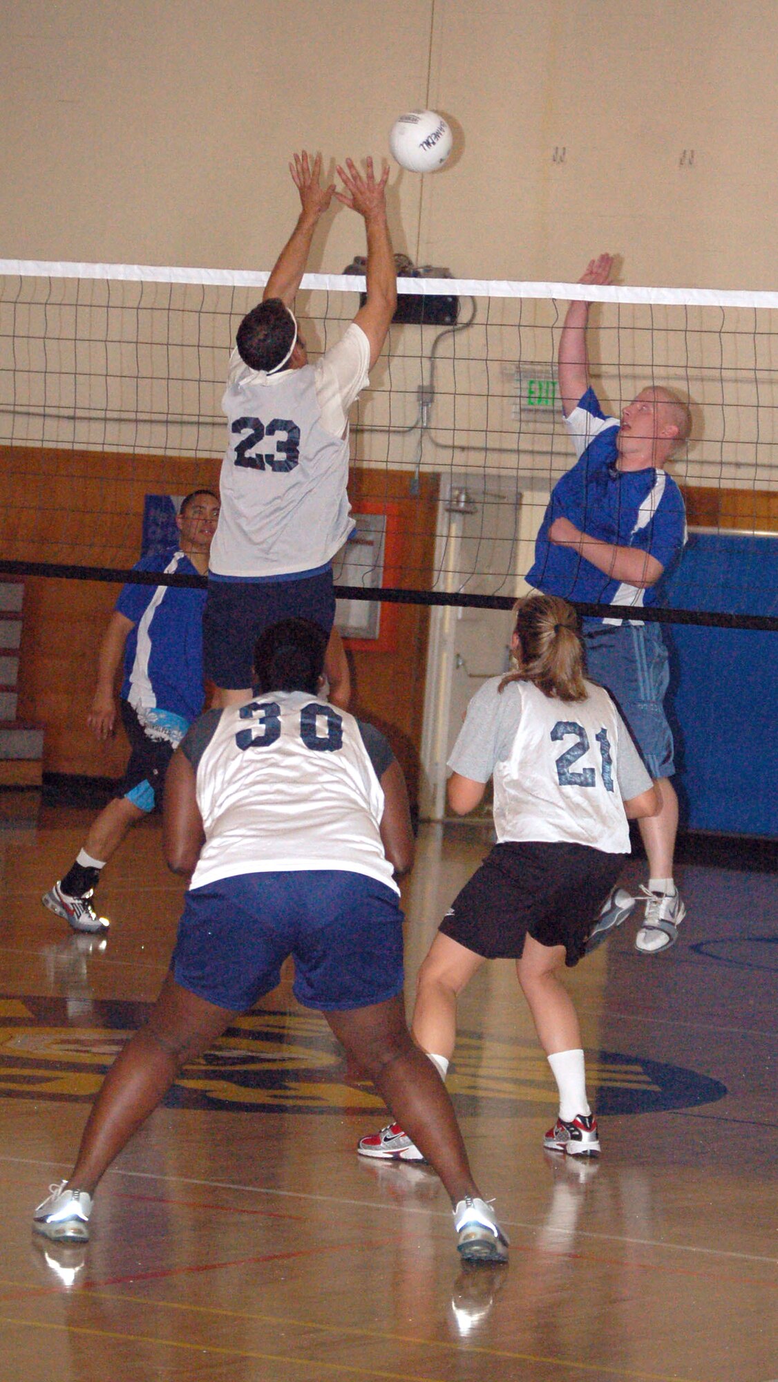 Jonathan Gambrell (right), player with the 95th Communications Group, spikes as Ian Moreno (jersey No. 23), player with the 419th Flight Test Squadron, blocks during the intramural volleyball championship at the Rosburg Fitness Center on Monday. The 419th FLTS defeated the 95th CG on a back-to-back, double-elimination game, 26-24, 25-12, 25-14 and 25-15, and clinched the championship title. (Photo by Airman 1st Class Julius Delos Reyes)