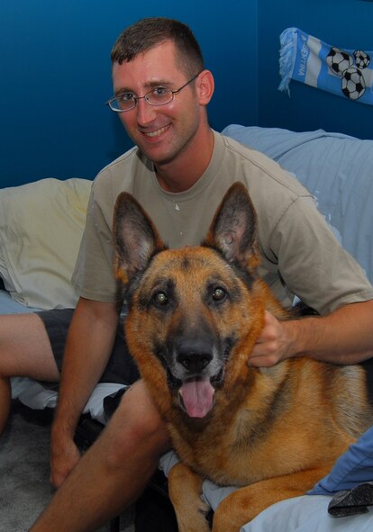 Staff Sgt. Morgan Maul, 23rd Security Forces Squadron military working dog handler, with retired MWD Ajax. Sergeant Maul adopted Ajax after the dog retired. (U.S. Air Force photo by Tech. Sgt. Parker Gyokeres)