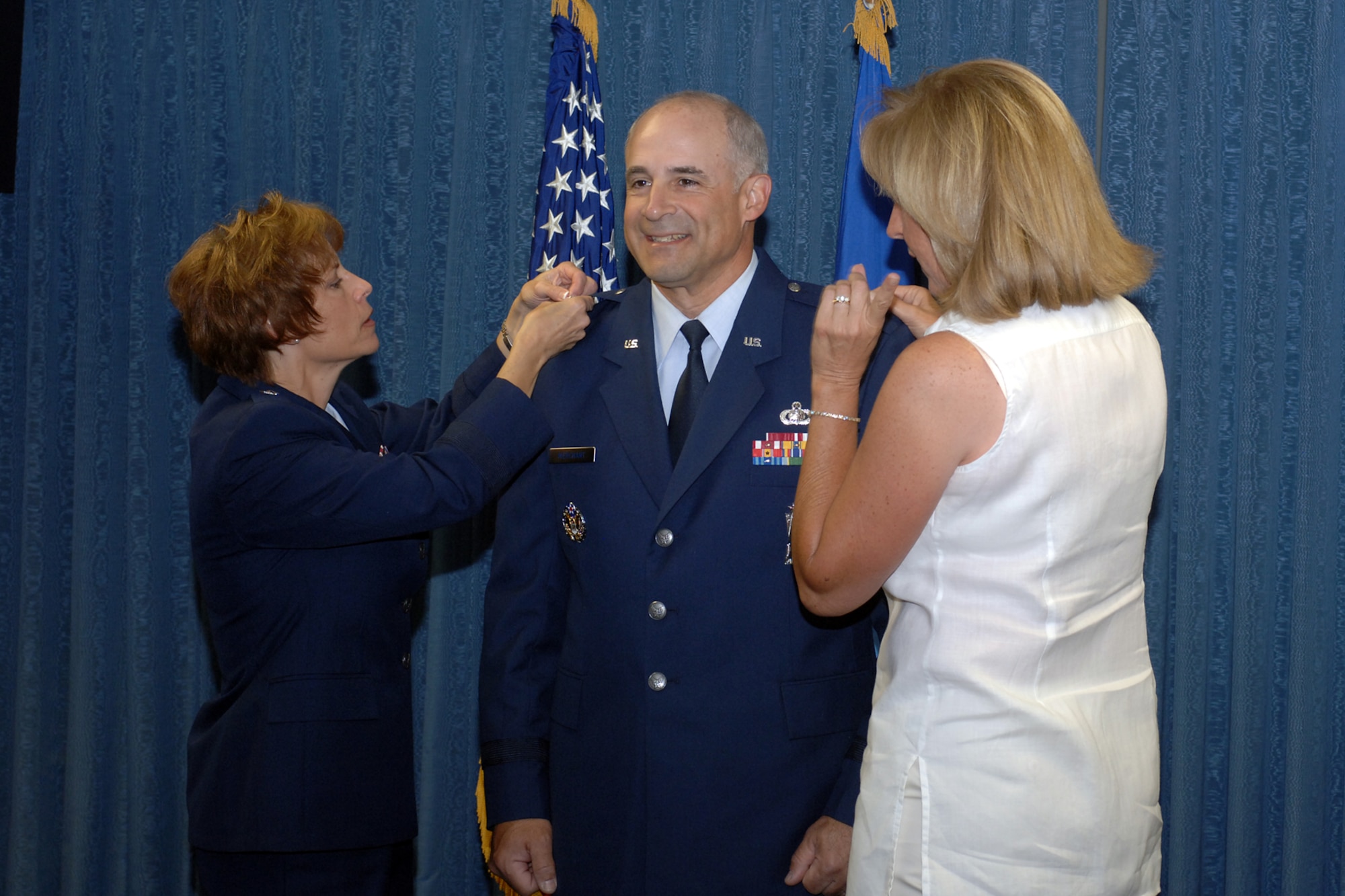 HILL AIR FORCE BASE, Utah--Colonel Kenneth Merchant, vice commander for the Ogden Air Logistics Center, gets his brigadier general star pinned on by Brigadier General Kathleen Close, Ogden ALC commander, and his wife Sue during a promotion ceremony held in his honor July 3. (U.S. Air Force photo by Alex R. Lloyd)