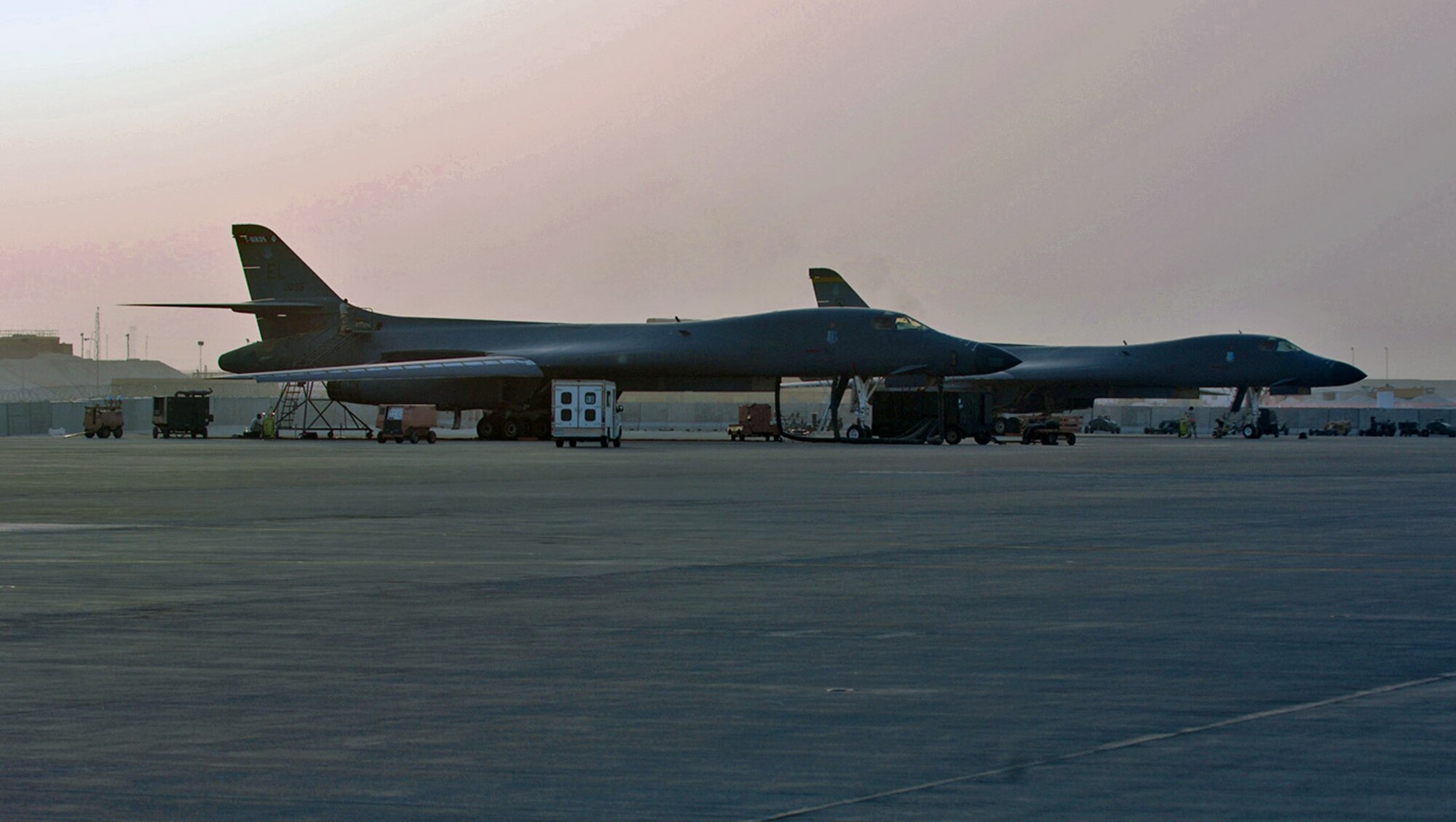 The sun sets as B-1B Lancers stand ready on a flightline at a forward deployed location in Southwest Asia. The B-1 supports both Operation Enduring Freedom and Operation Iraqi Freedom with close-air support. (U.S. Air Force photo/Master Sgt. Ken Stephens)
