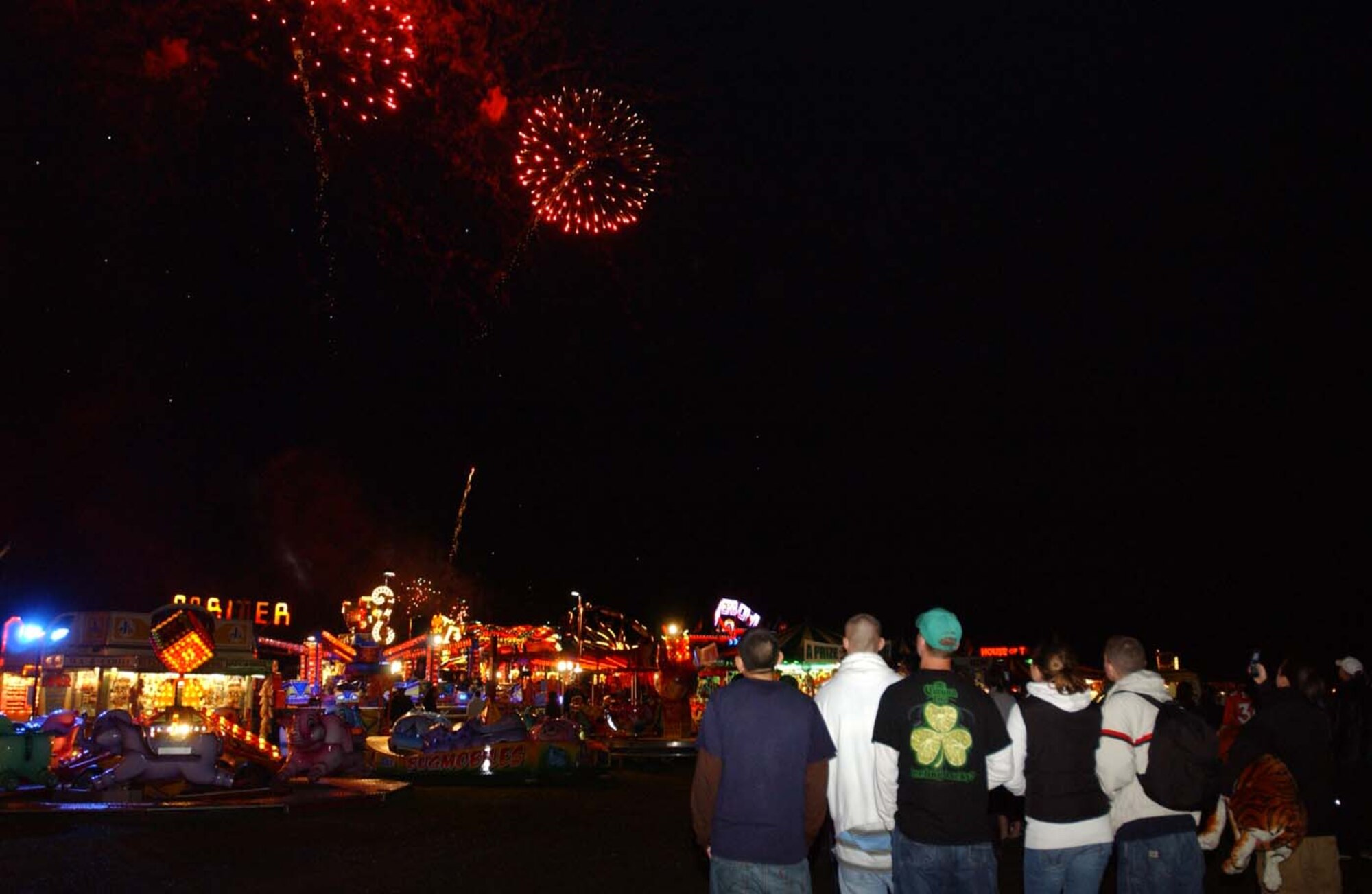 Despite the rain and bad weather, people stayed to watch the fireworks at the July 4 Independence Day celebrations at RAF Feltwell. The base was open to the general public and both British and American spent time enjoying the amusements, American food and a car show. (U.S. Air Force photo by airman Brad Smith)