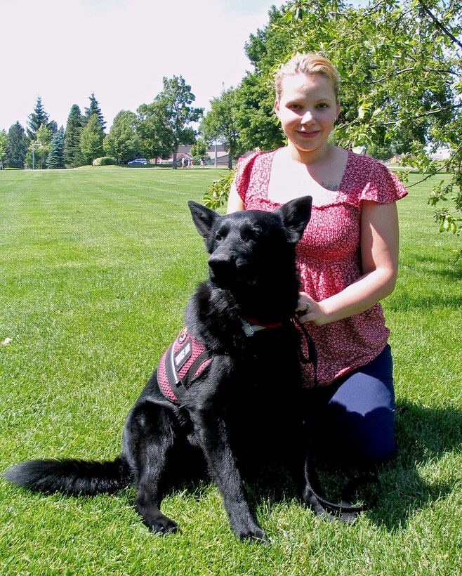Kimberly Hawks kneels with her medical alert dog, Zeuss, an 18-month-old German shepherd June 22 at Fairchild Air Force Base, Wash. Ms. Hawks obtained Zeuss from a breeder in Seattle after detailed research about medical dogs and their services. Zeuss comes from an accomplished canine family; his parents are both champion show dogs, and his brother is a drug detection dog in Arizona. (U.S. Air Force photo/ Staff Sgt. Connie L. Bias) 
