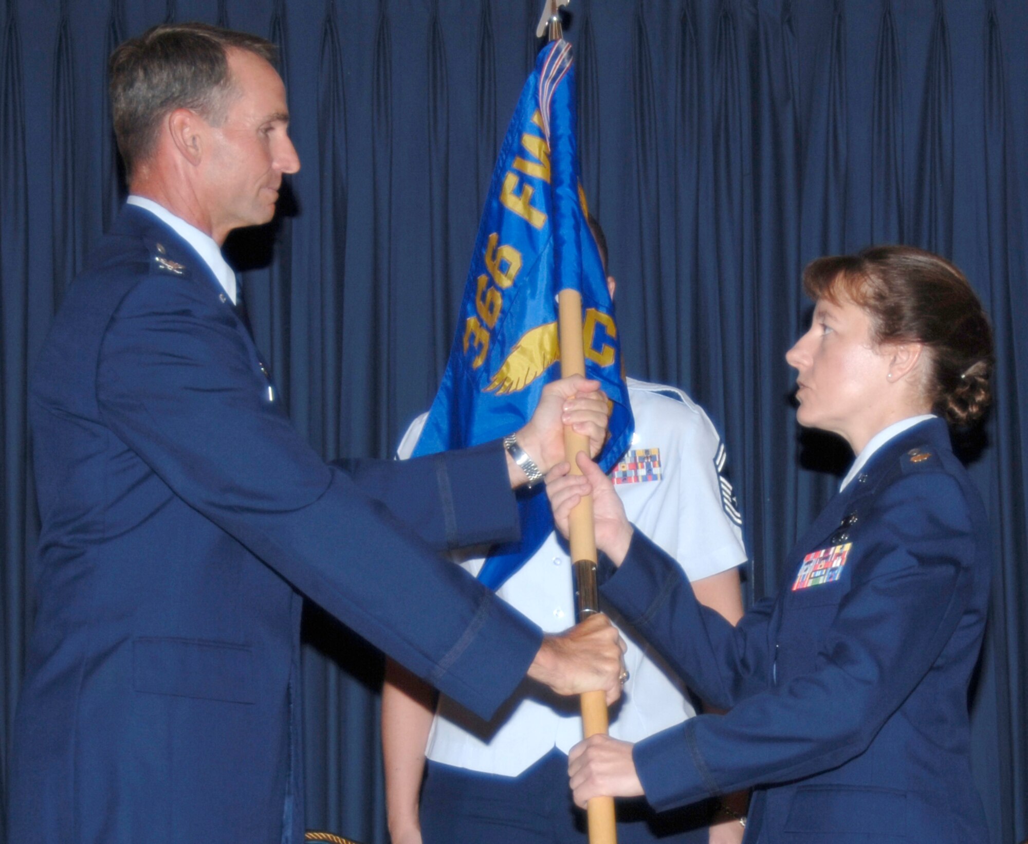 MOUNTAIN HOME AIR FORCE BASE, Idaho -- Col. Tony Rock, 366th Fighter Wing commander, passes the 366th Comptroller Squadron guidon to Maj. Terri Jones, the squadron’s new commander, at a change of command ceremony here July 9. Major Jones came to Mountain Home after graduating from the Air Command and Staff College at Maxwell Air Force Base, Ala. The squadron’s outgoing commander, Maj. David Vaclavik, left the base to attend this intermediate officer development course. (Air Force photo/Airman 1st Class Stephany Miller)