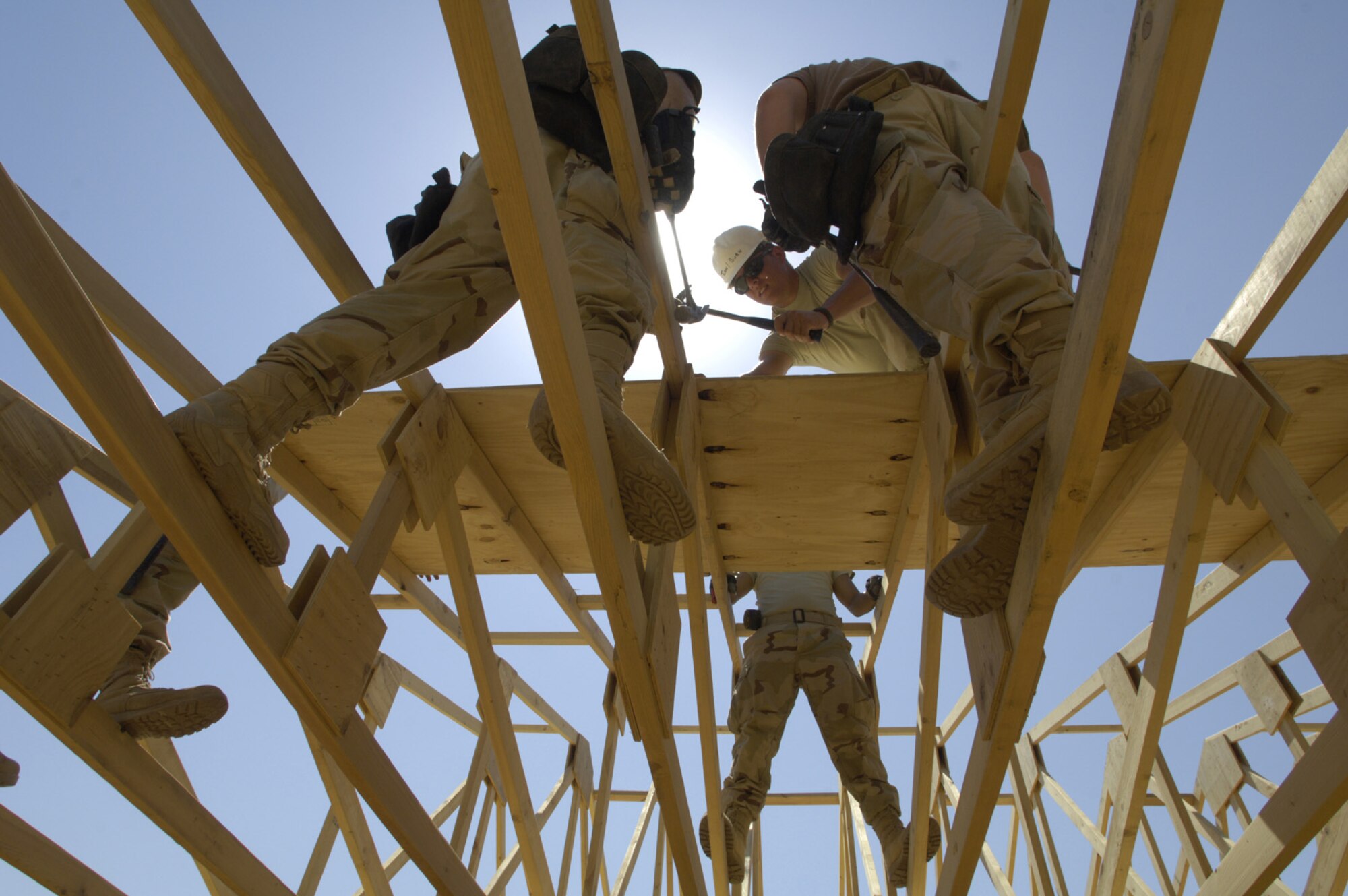 FORWARD OPERATING BASE KALSU, Iraq -- U.S. Air Force Airmen with the 557th Expeditionary RED HORSE Squadron, work on the roof of a tactical operations center June 22, 2007. The Rapid Engineer Deployable Heavy Operational Repair Squadron Engineers RED HORSE Airmen are forward deployed from Balad Air Base, Iraq, and are tasked to build four tactical operations centers for the Army's 2nd Brigade combat team, 3rd Infantry Division headquartered here. The 2/3 ID is currently running operations out of tents. The Air Force RED HORSE unit, made up of Air Guard, Reserve and active duty Airmen, was requested, by the Army, to come into this "Triangle of Death" location because of their self-suffiency and for the multiple skill sets they bring to a project. Besides the TOCs the RED HORSE Airmen are working on several other projects at the FOB. (U.S. Air Force photo/Master Sgt. Jim Varhegyi)