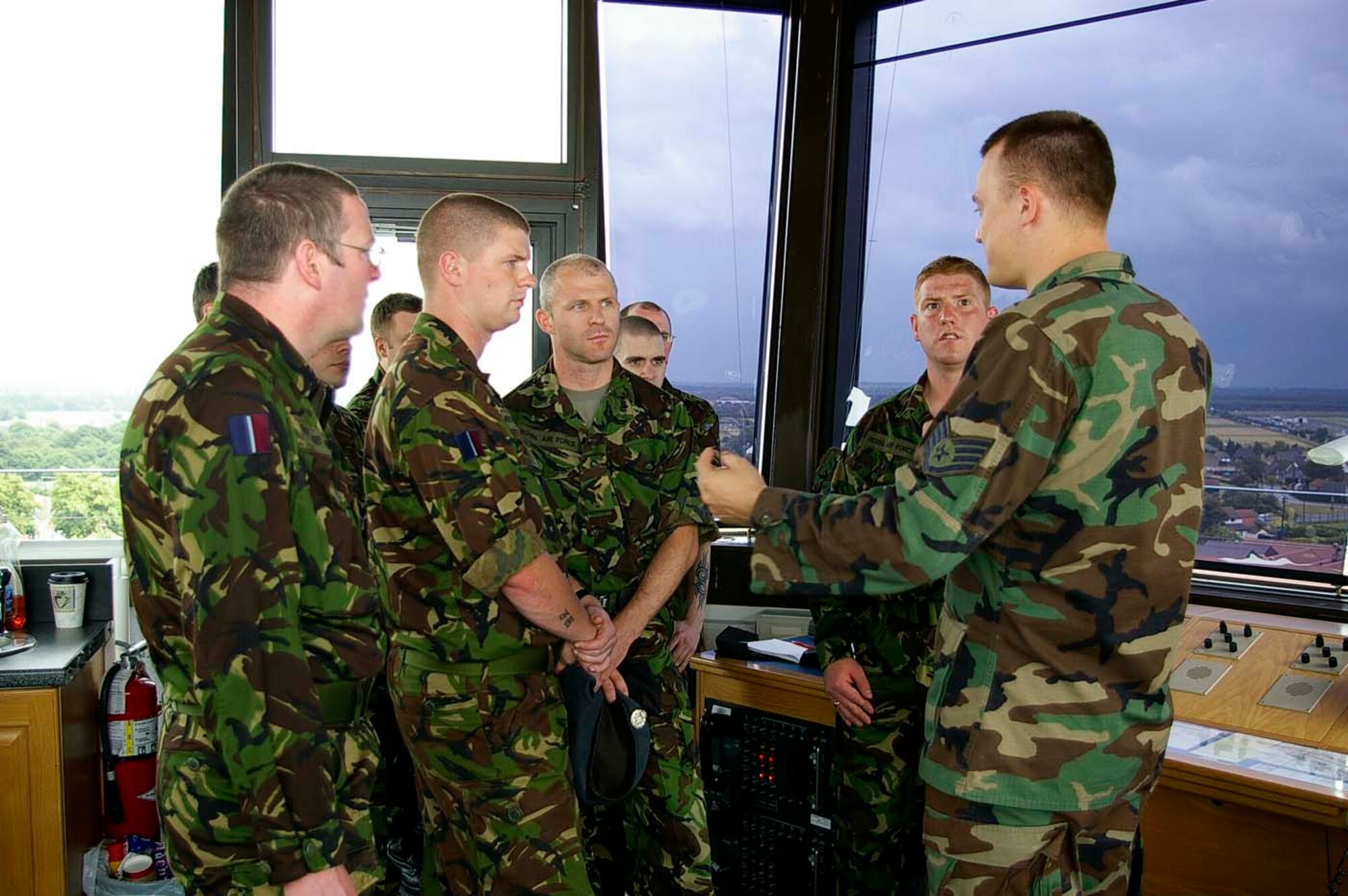 Staff Sgt. William MacArthur, right, 100th Operations Support Squadron Air Traffic Control Tower, explains the role and mission of the tower at RAF Mildenhall to members from a Royal Air Force regiment from RAF Marham, near King's Lynn, Norfolk, June 29. The RAF troops visited the base for force development training. They also visited the KC-135 flight simulator, saw a static display of a KC-135, and watched the base promotion ceremony take place, as well as taking part in team building activities at the professional devleopment center. The visit helped strengthen the close working relationship between the British RAF and the U.S. Air Force. (U.S. Air Force photo by Karen Abeyasekere)
