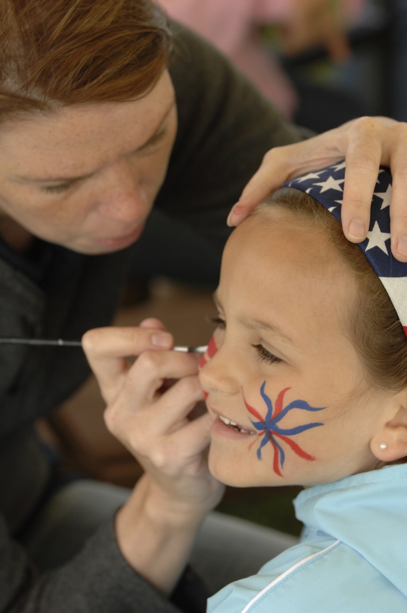 Emily Hendershot, daughter of Hope Hendershot, 100th Services Squadron gets her face painted during the 4th of July celebration on RAF Feltwell. (U.S. Air Force photo by Airman 1st Class Jessica Snow.)