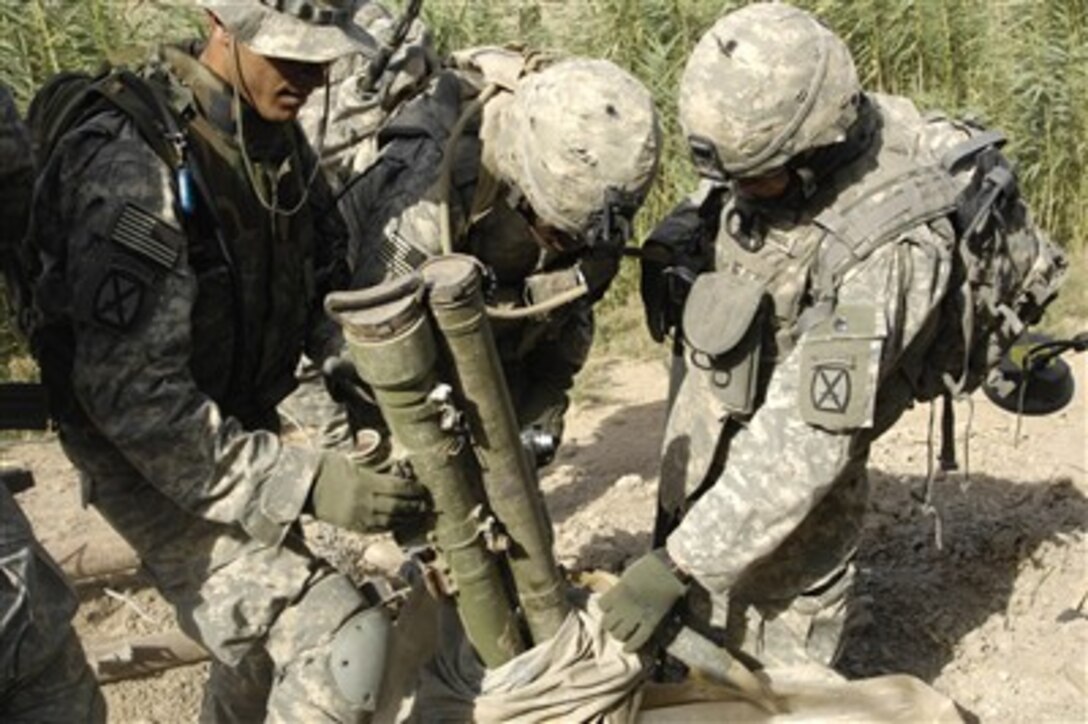 U.S. Army soldiers uncover anti-tank missiles and their hand-held launchers while searching for buried weapons at a remote village outside of Forward Operating Base Lutafiyah located in Baghdad, Iraq, on July 5, 2007.  The soldiers are attached to Bravo Company, 2nd Battalion, 15th Field Artillery Regiment.  