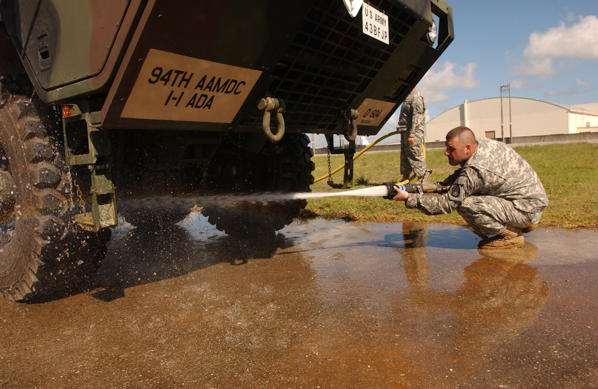 An Army soldier from the 1-1 Air Defense Artillery Brigade washes a Hemmet along with the Patriot Advanced Capability missile equipment at Kadena Air Base, Japan, July 11, 2007. The 1-1 ADA stored their most valuable equipment in a hangar near the flightline in preparation for Typhoon Man-Yi, the first typhoon of the year for Okinawa. Before having them stored, both the equipment and vehicle are washed at Papa ramp to prevent foreign object damage.  U.S. Air Force photo/Staff Sgt. Reynaldo Ramon

